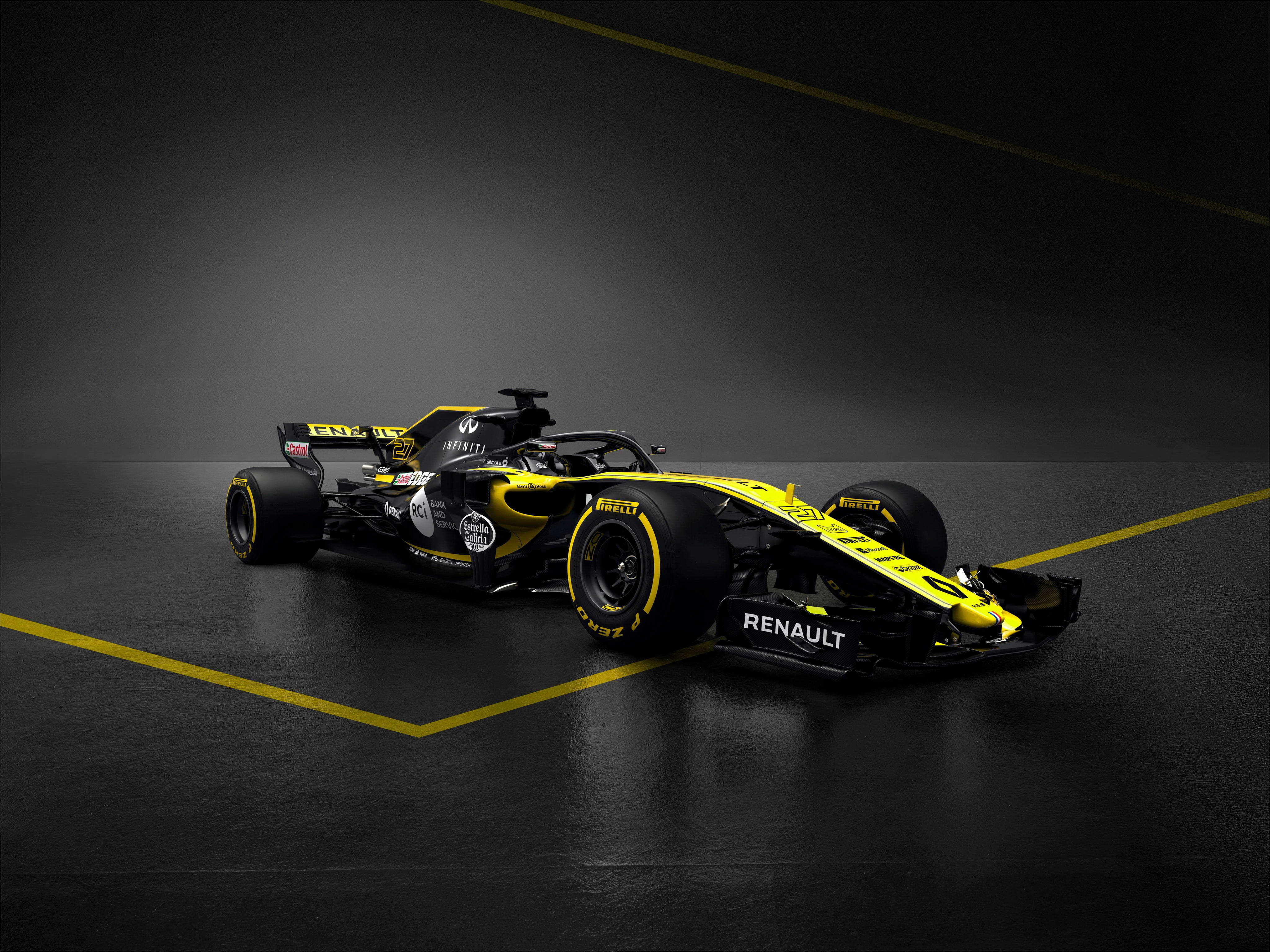F1 桌布 壁紙 — 一輛流線型的雷諾一級方程式賽車，採用鮮黃色和黑色，停在深色地板上，地板上有大膽的黃色線條，在戲劇性的攝影棚燈光下。