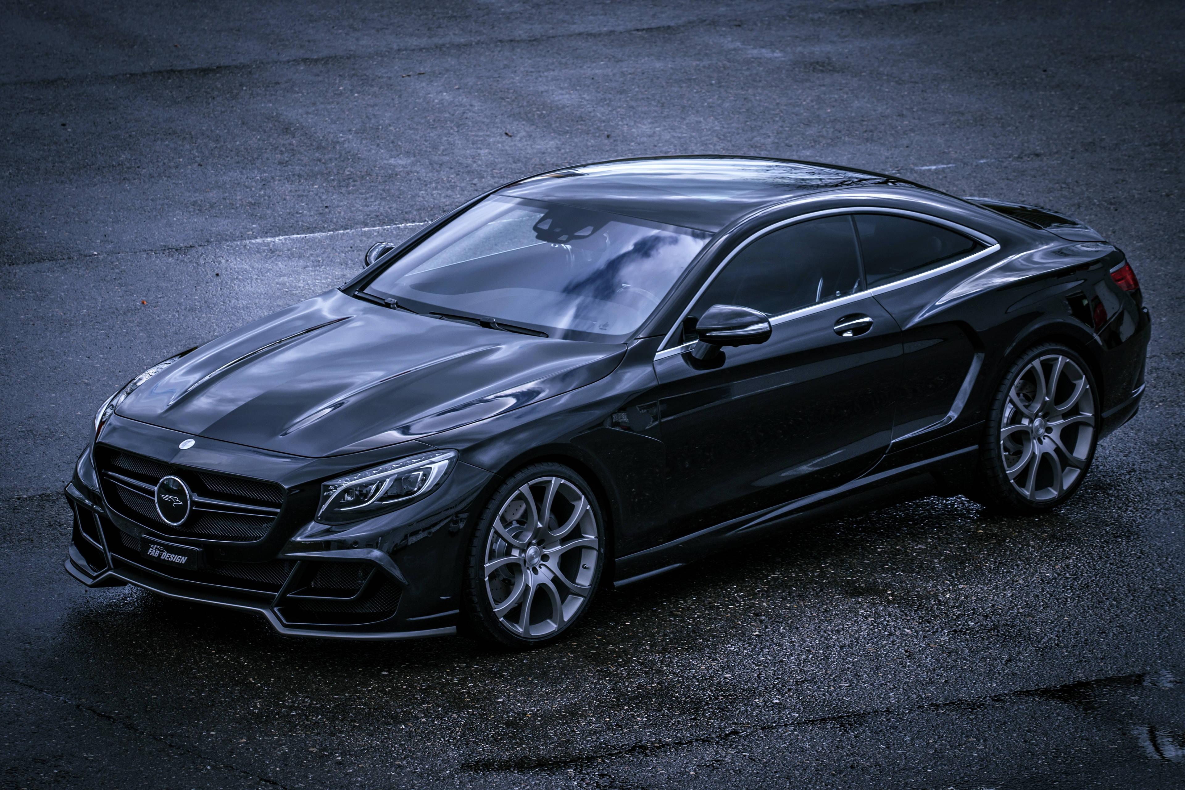 benz 4K 桌布 壁紙 — 一輛流線型的黑色 Mercedes-AMG S63 Coupe 在昏暗燈光下於濕漉漉的瀝青路面上閃耀。