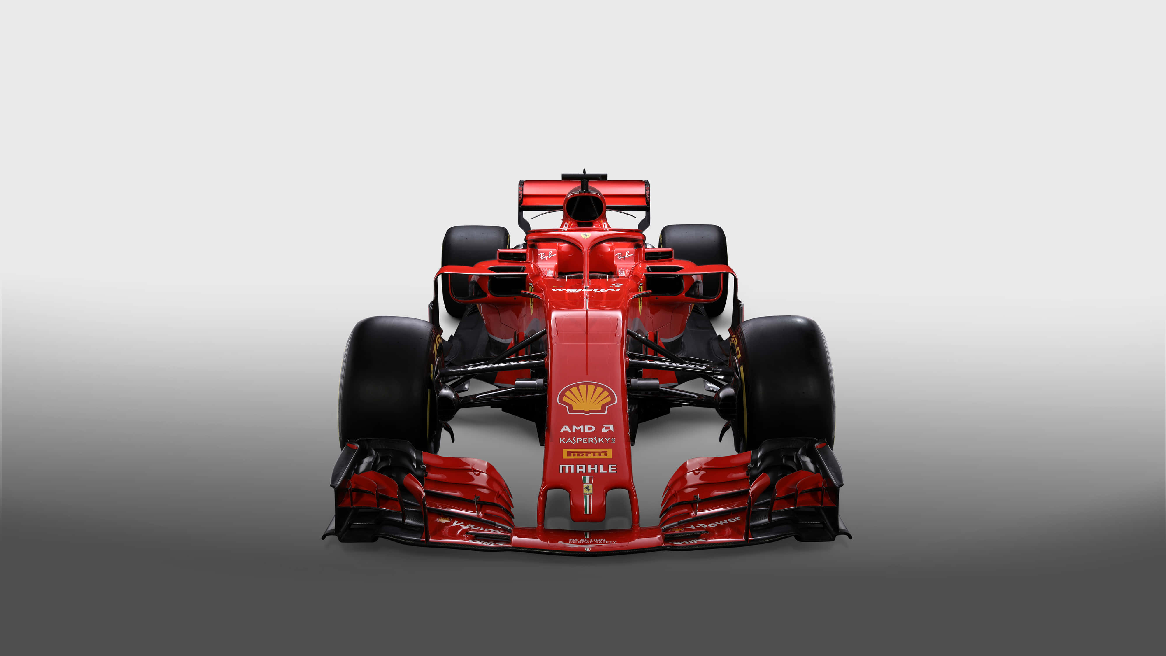 ferrari f1 2018 桌布 壁紙 — 一輛流線型紅色一級方程式賽車面向前方，背景為漸變灰色，展示空氣動力學設計和贊助商標誌。