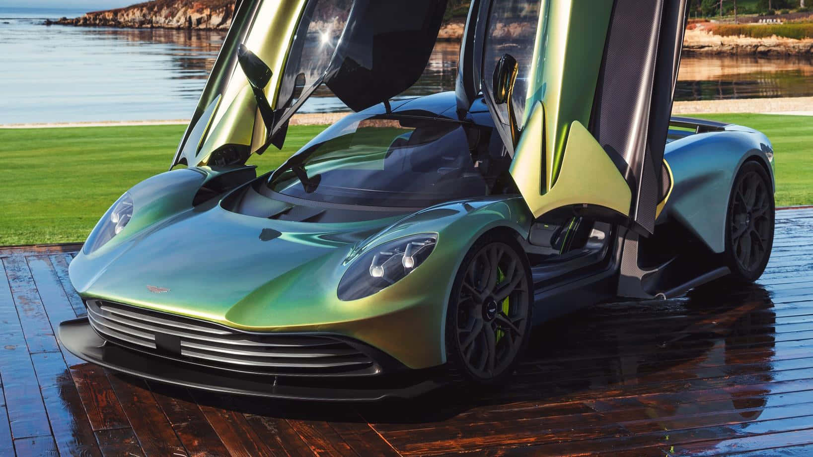 奧斯頓馬丁 桌布 壁紙 — 一輛流線型綠色Aston Martin，鷗翼車門打開，停在寧靜湖邊的濕木碼頭上。