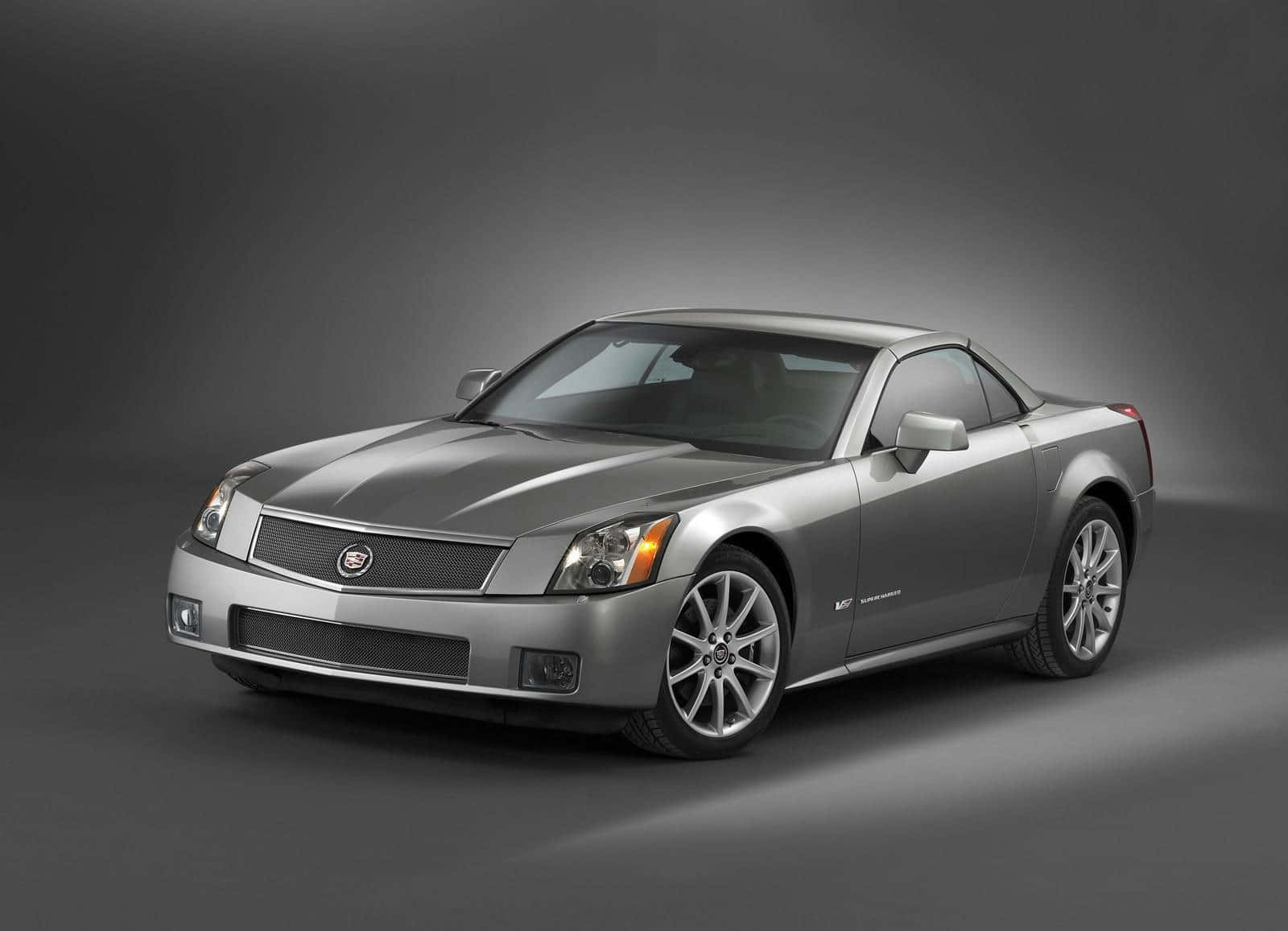 Cadillac Xlr 桌布 壁紙 — 一輛流線型銀色Cadillac XLR敞篷跑車在漸變灰色攝影棚背景前擺拍。