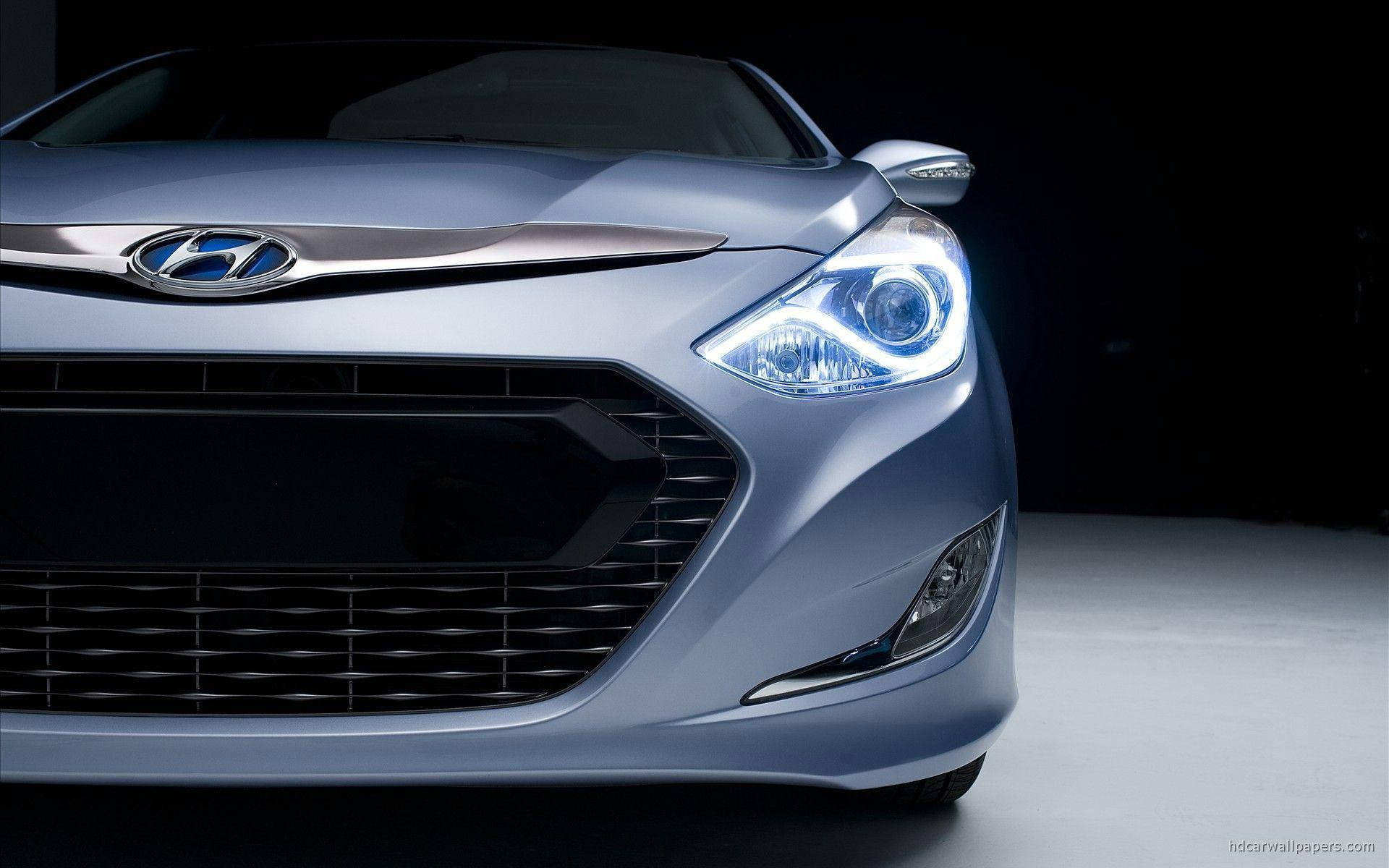 Hyundai 桌布 壁紙 — 一輛流線型銀色現代汽車的前臉在攝影棚燈光下閃耀，配備銳利頭燈和醒目格柵。