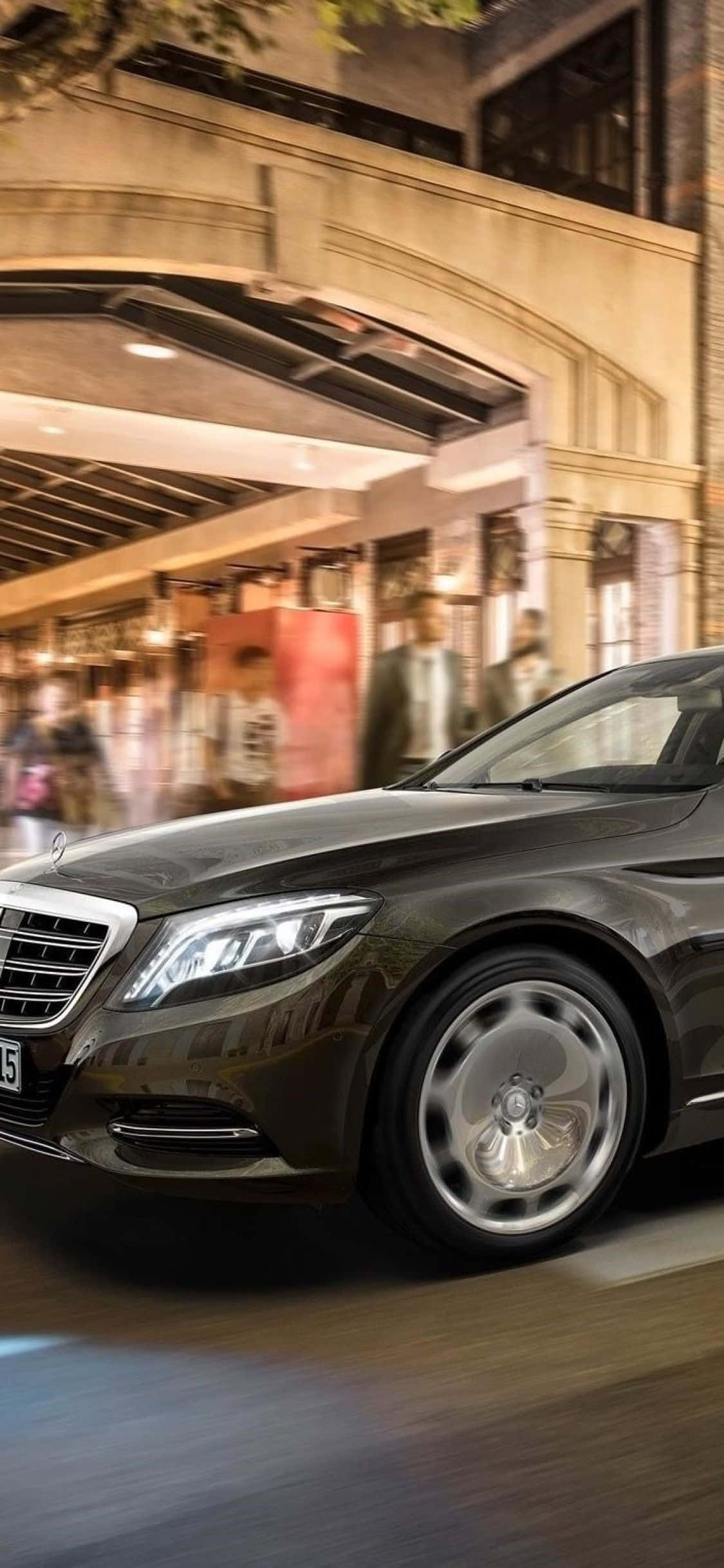 Mercedes 桌布 壁紙 — 一輛流線型黑色豪華轎車在夜間溫暖照明的城市街道上疾馳，背景呈現動態模糊效果。