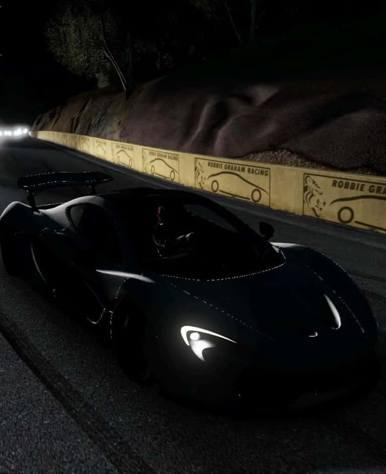 黑色跑車在夜間在有發光護欄的照明賽道上比賽。 — Project Cars 壁紙