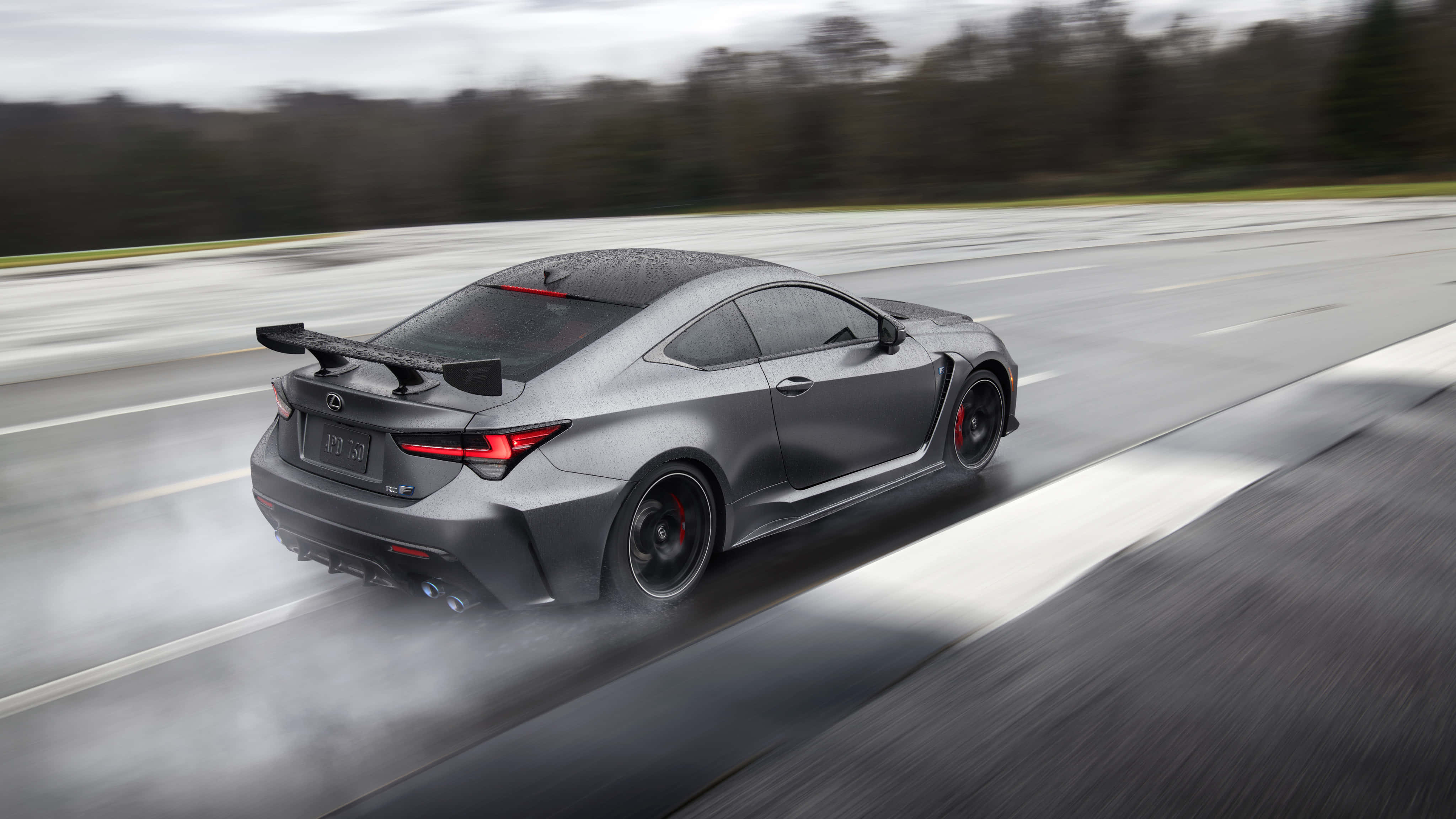 Lexus Rc F 桌布 壁紙 — 一輛消光灰色的Lexus RC F跑車在陰天潮濕的高速公路上甩尾，輪胎冒出滾滾濃煙。