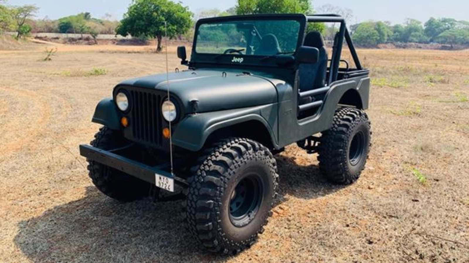 Jeep Cj 桌布 壁紙 — 一輛消光綠色的經典Jeep Wrangler，配備超大輪胎，停在乾燥的土地上，光線明亮。