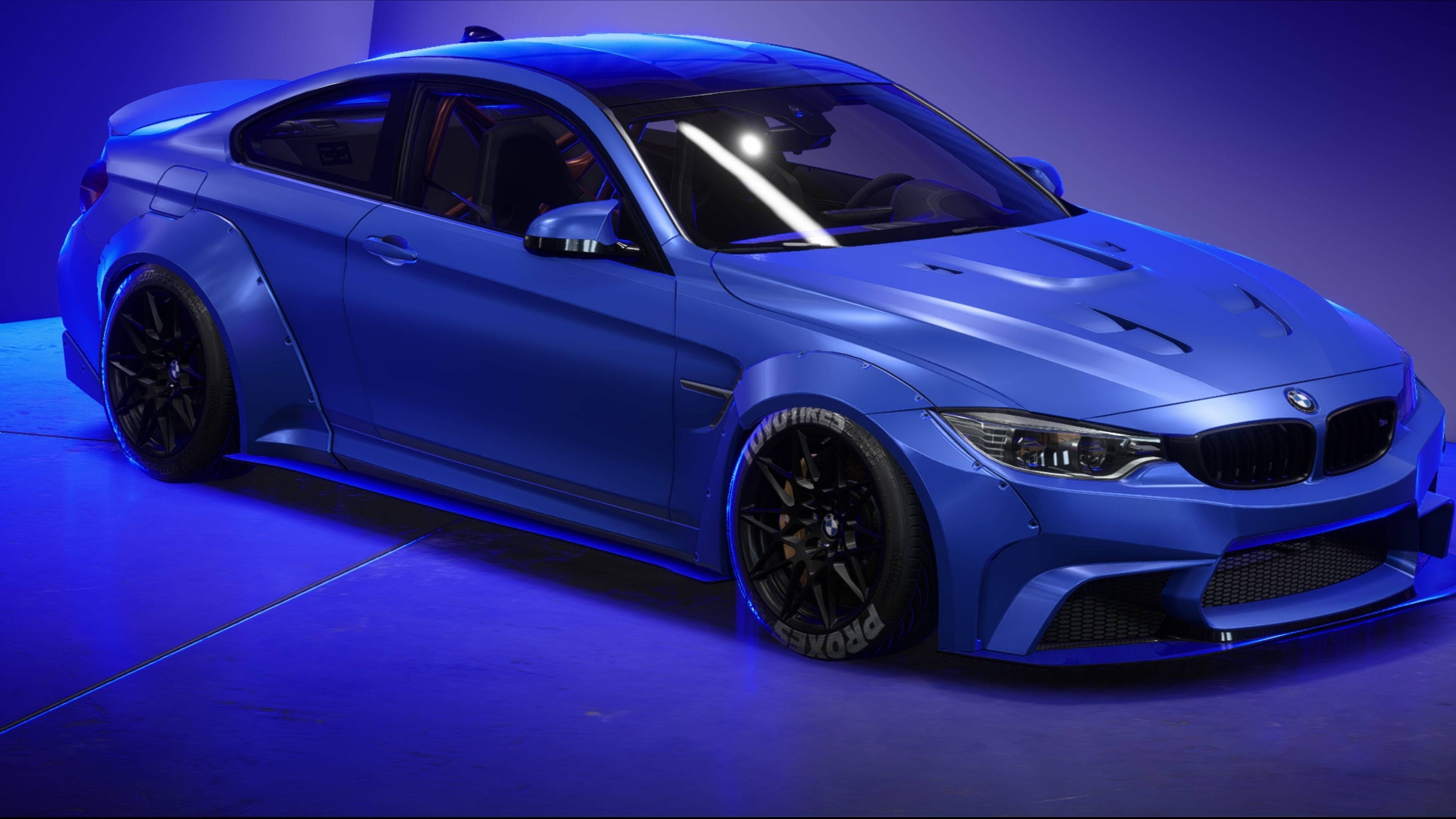 藍色 桌布 壁紙 — 一輛消光藍色BMW M4雙門轎跑車，配備黑色輪圈和侵略性造型，在戲劇性的藍色工作室燈光下閃耀。
