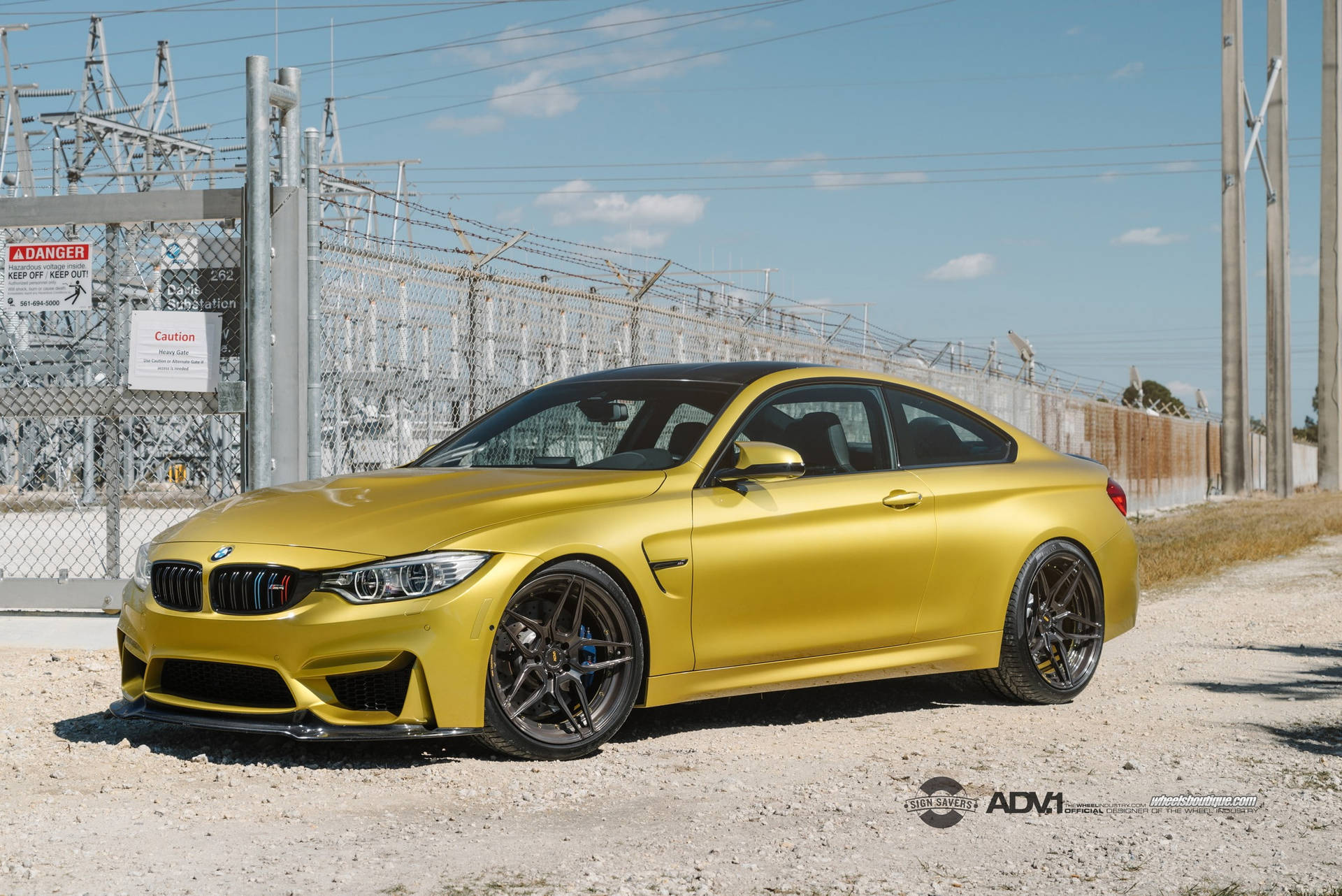 消光金色BMW M4跑車停在工業變電站附近。