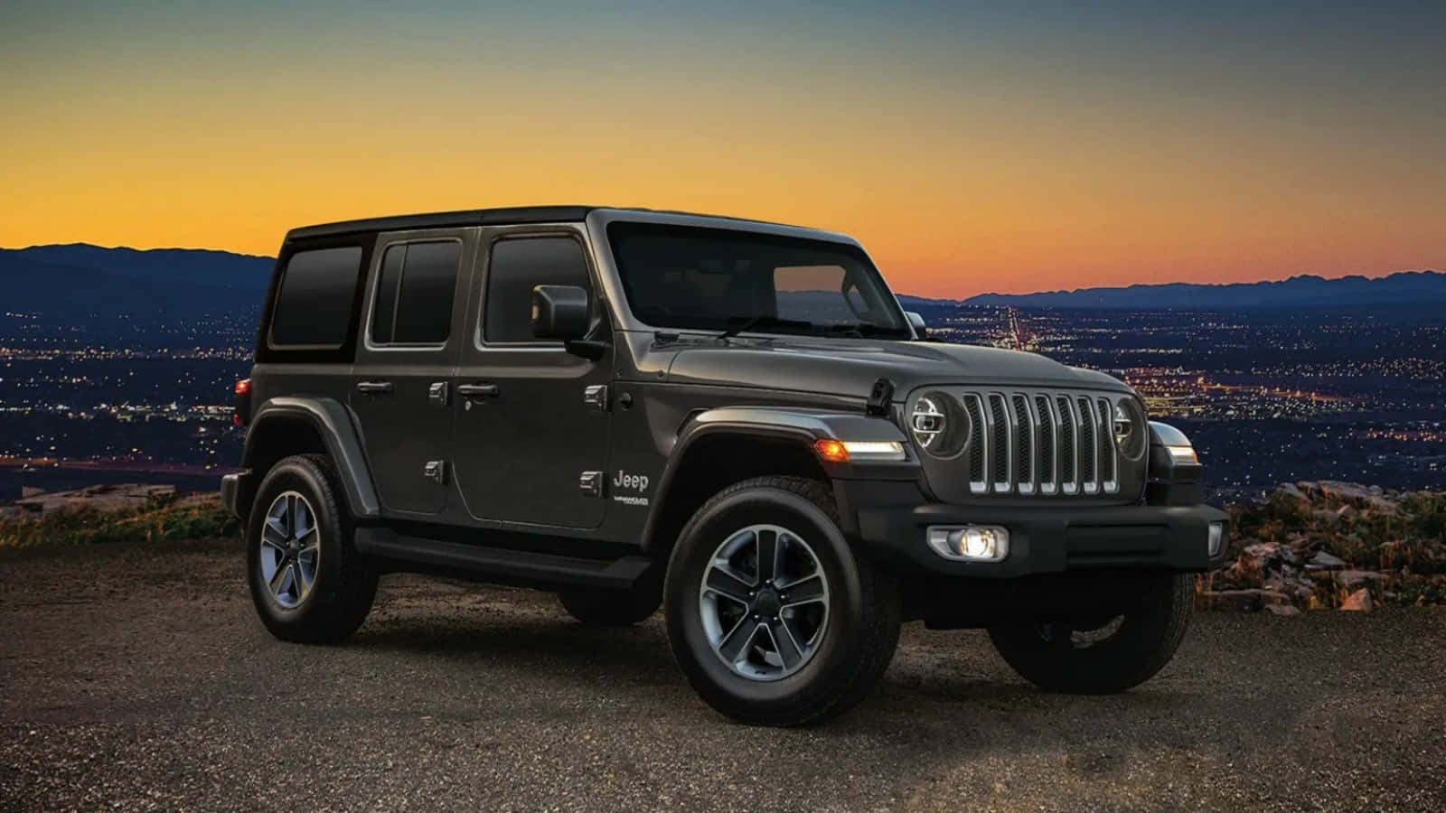 Jeep Wrangler 桌布 壁紙 — 一輛消光黑色Jeep Wrangler停在山頂，俯瞰夕陽下的廣闊城市，天空呈現溫暖的橙色和紫色。