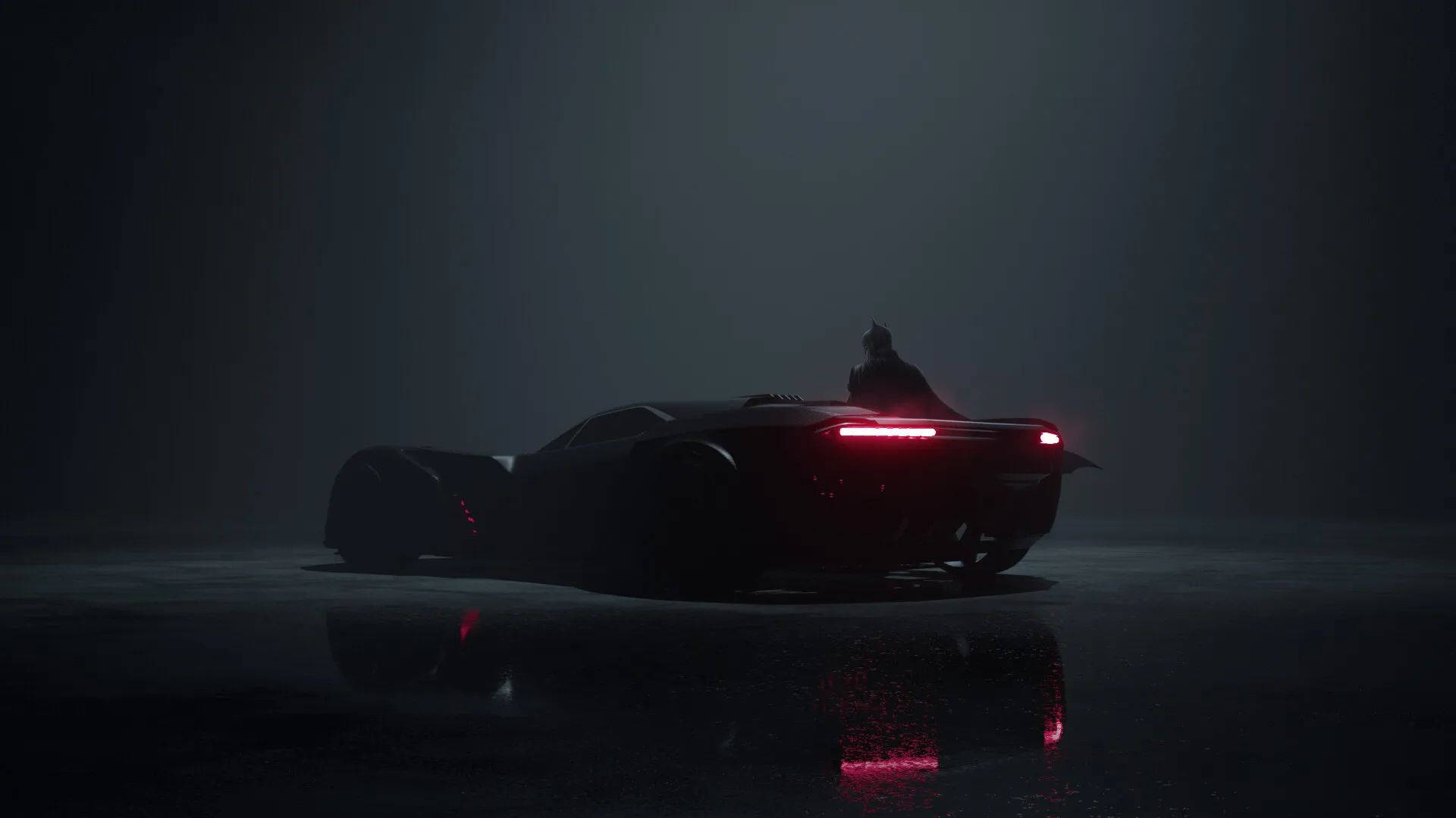Batmobile 桌布 壁紙 — 一輛深色裝甲車發出紅色尾燈，在潮濕的路面上反射，一個披著斗篷的身影站在車尾，周圍環境霧氣瀰漫、光線昏暗。
