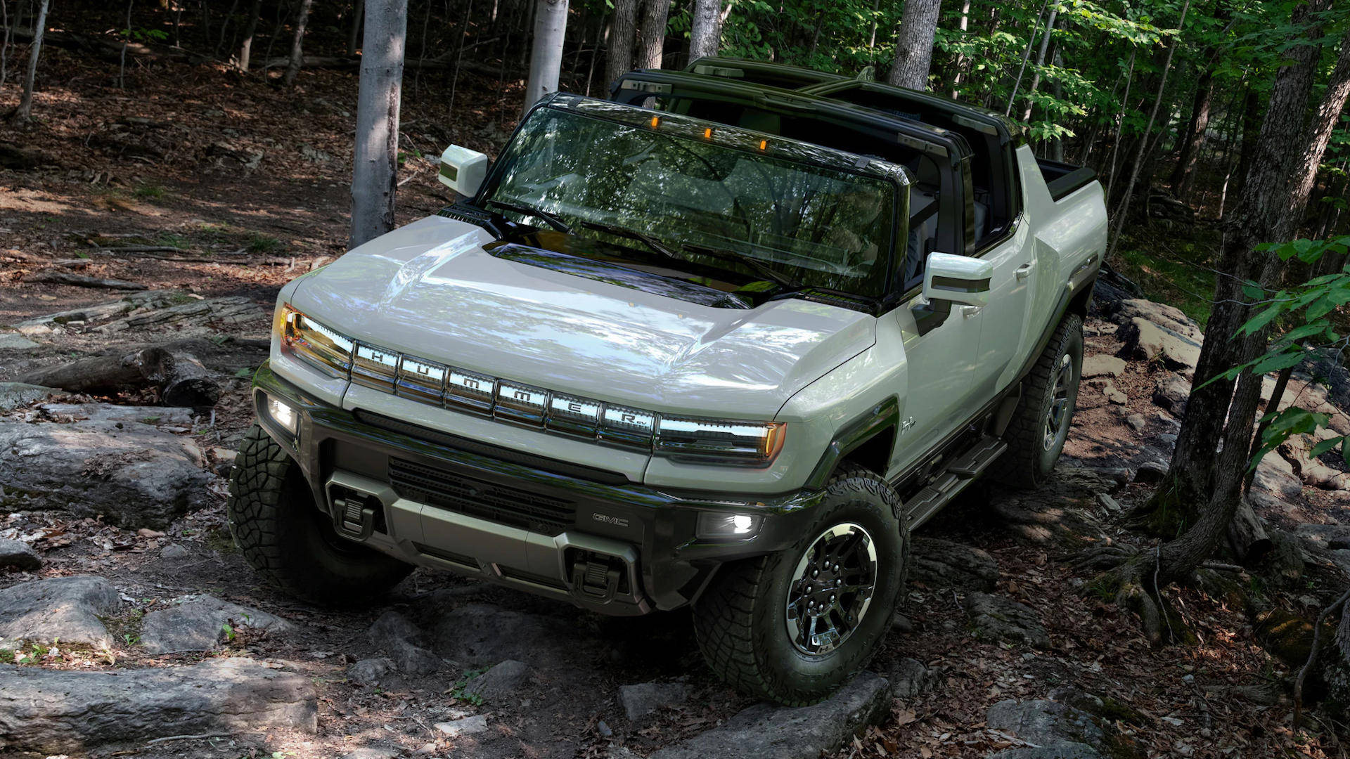 淺綠色Hummer EV pickup truck在岩石森林小徑上行駛。 — Toyota Supra Mk4 壁紙