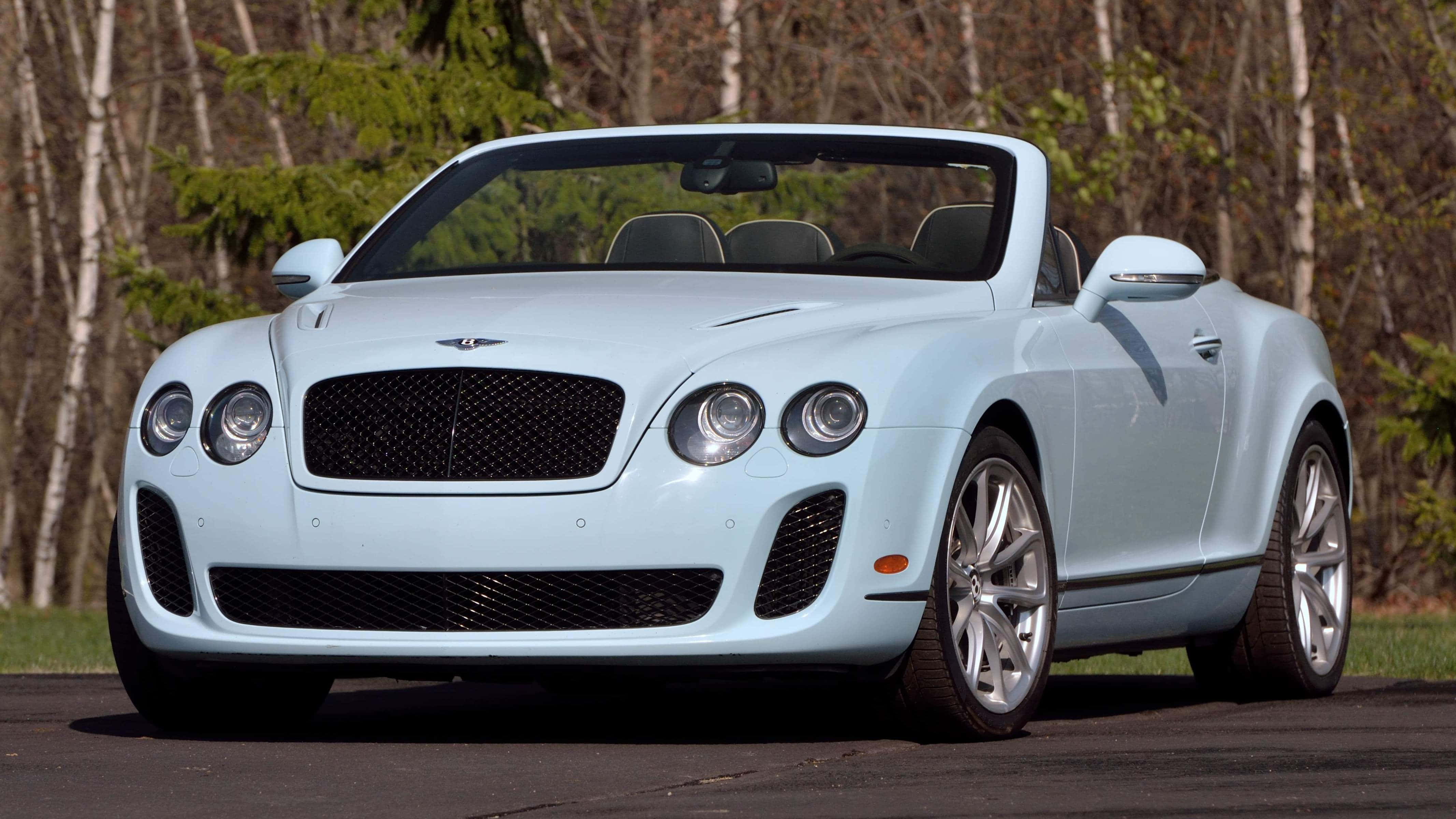 Bentley Continental Supersports 桌布 壁紙 — 一輛淺藍色賓利敞篷車停在柏油路上，背景有樹木。