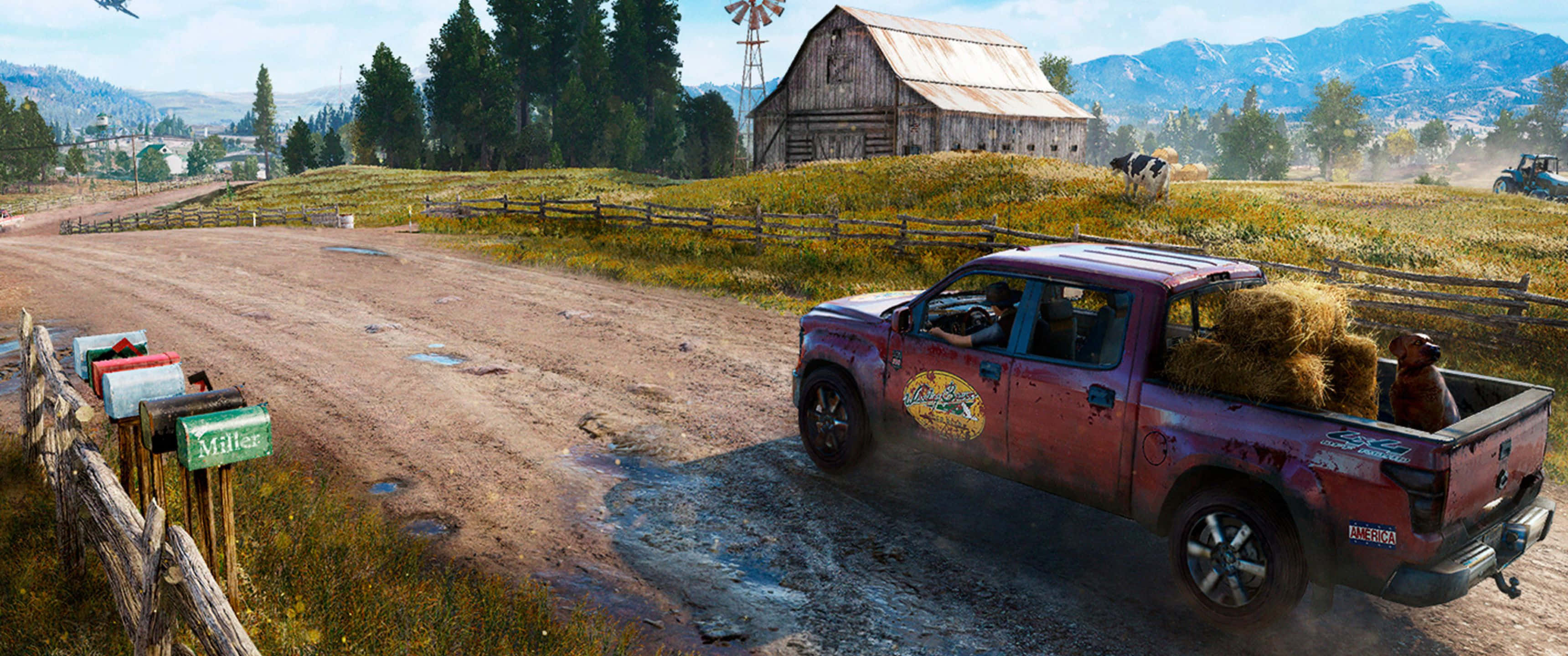 3440x1440p Far Cry 5 桌布 壁紙 — 一輛滿載乾草、佈滿灰塵的紅色小貨車行駛在鄉間泥路上，經過一座風化的穀倉和風車。