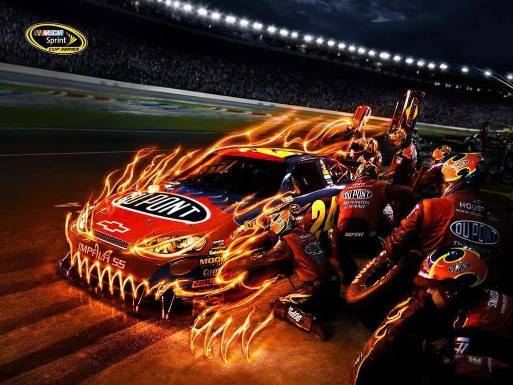 nascar 桌布 壁紙 — 一輛火焰從車身噴出的火熱NASCAR賽車，維修人員在夜間明亮的體育場燈光下工作。