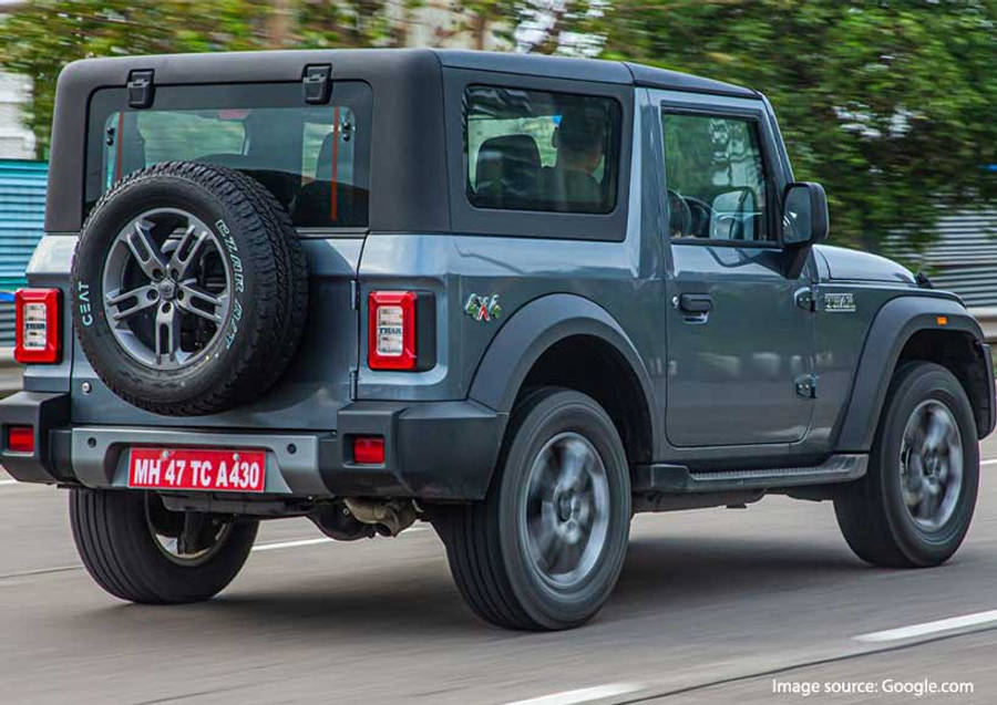 吉普 桌布 壁紙 — 一輛灰色鈴木 Jimny SUV 在道路上行駛，背景有模糊的綠色樹木。