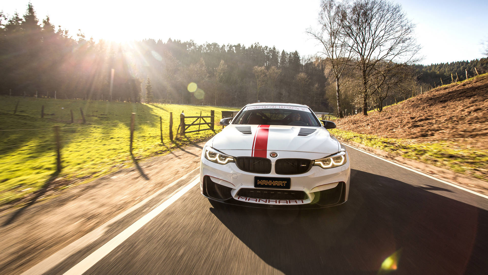 白色Manhart BMW M4在日落時分的鄉間道路上疾馳。 — Toyota Supra Mk4 壁紙