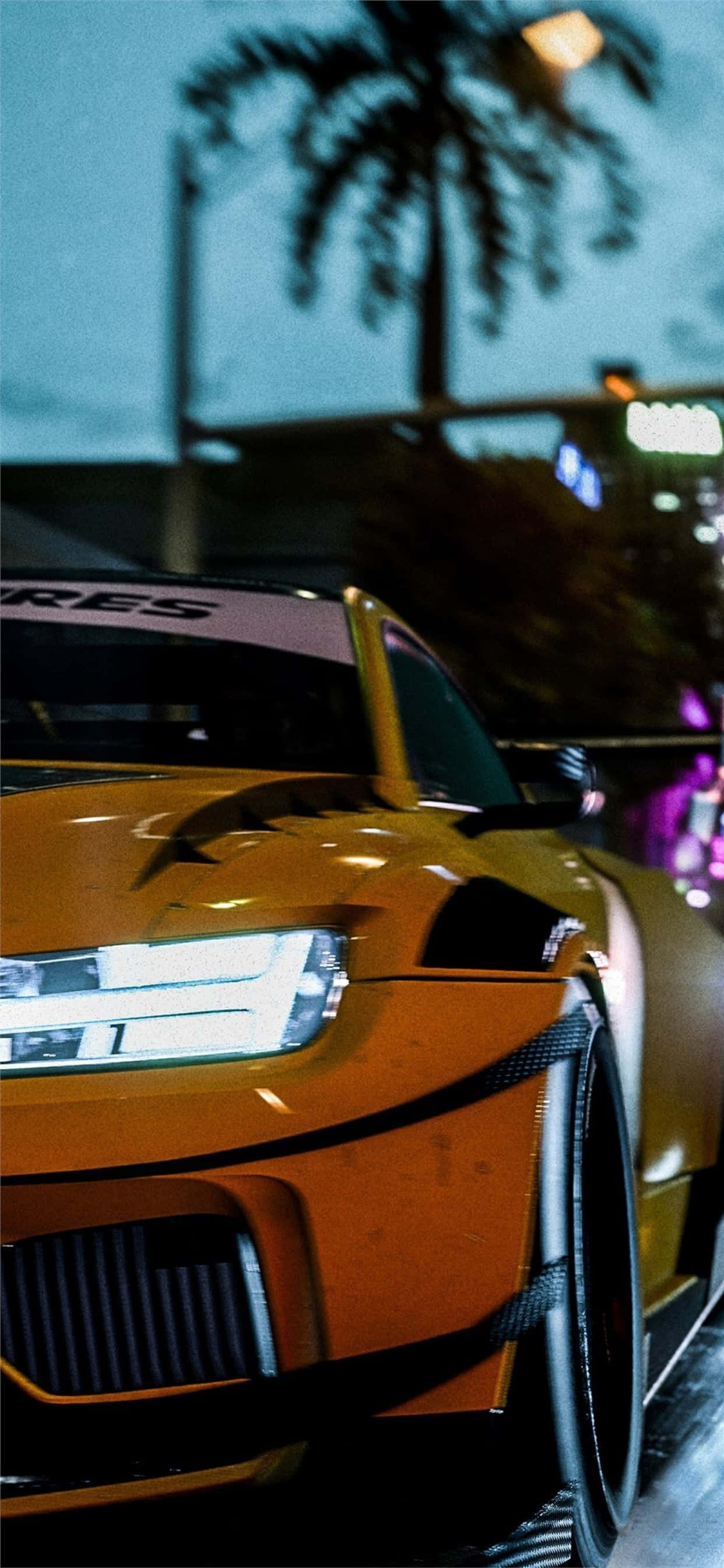 電玩遊戲 桌布 壁紙 — 一輛發光的橙色跑車在夜間停泊在棕櫚樹下，背景是城市燈光。