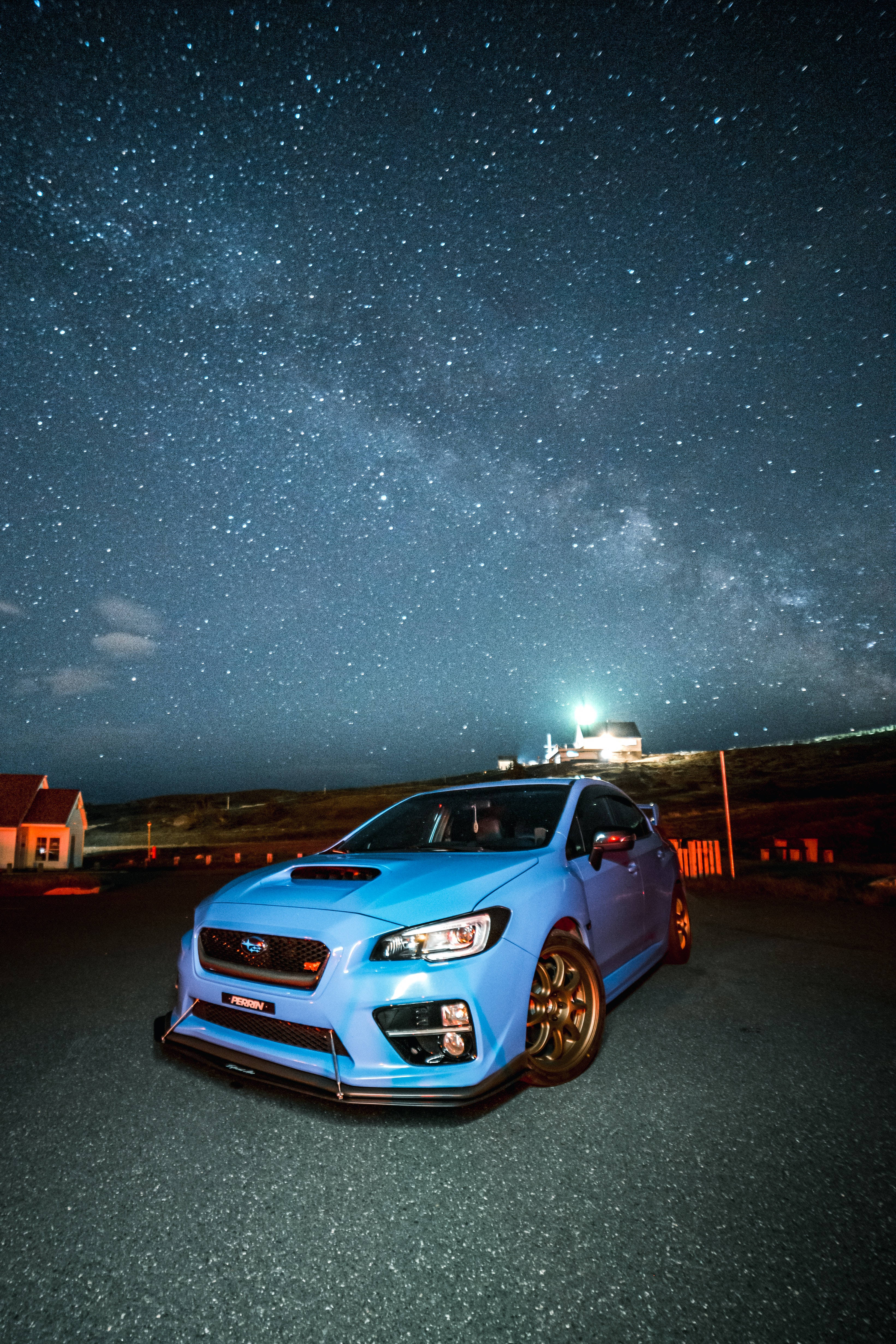 跑車 桌布 壁紙 — 一輛發光的藍色Subaru WRX STI停泊在星空下，銀河拱橋般橫跨天際。
