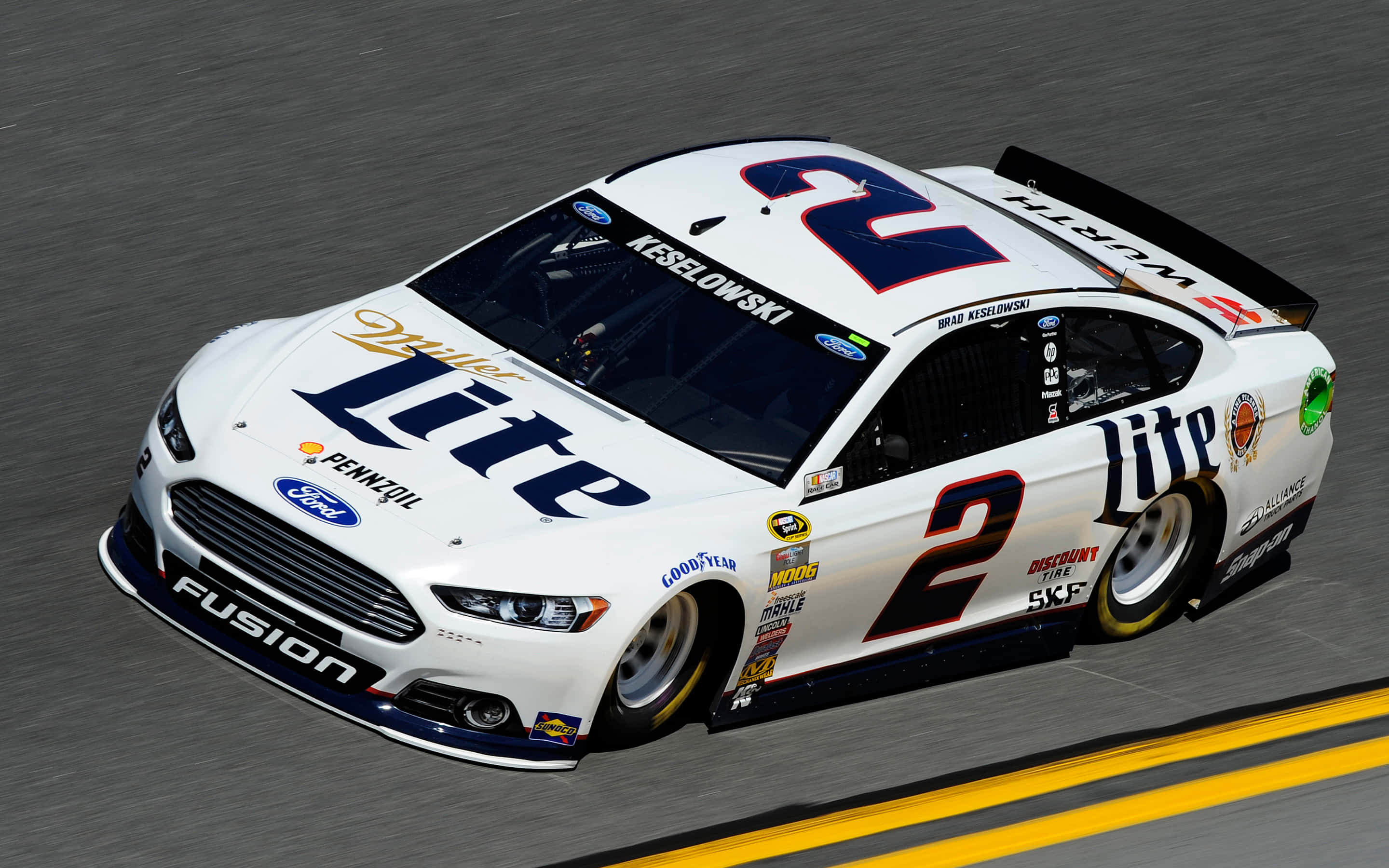 美國 桌布 壁紙 — 一輛白色 #2 Miller Lite Ford Fusion NASCAR 賽車在賽道上高速奔馳，帶有模糊動態效果和黃色賽道線。
