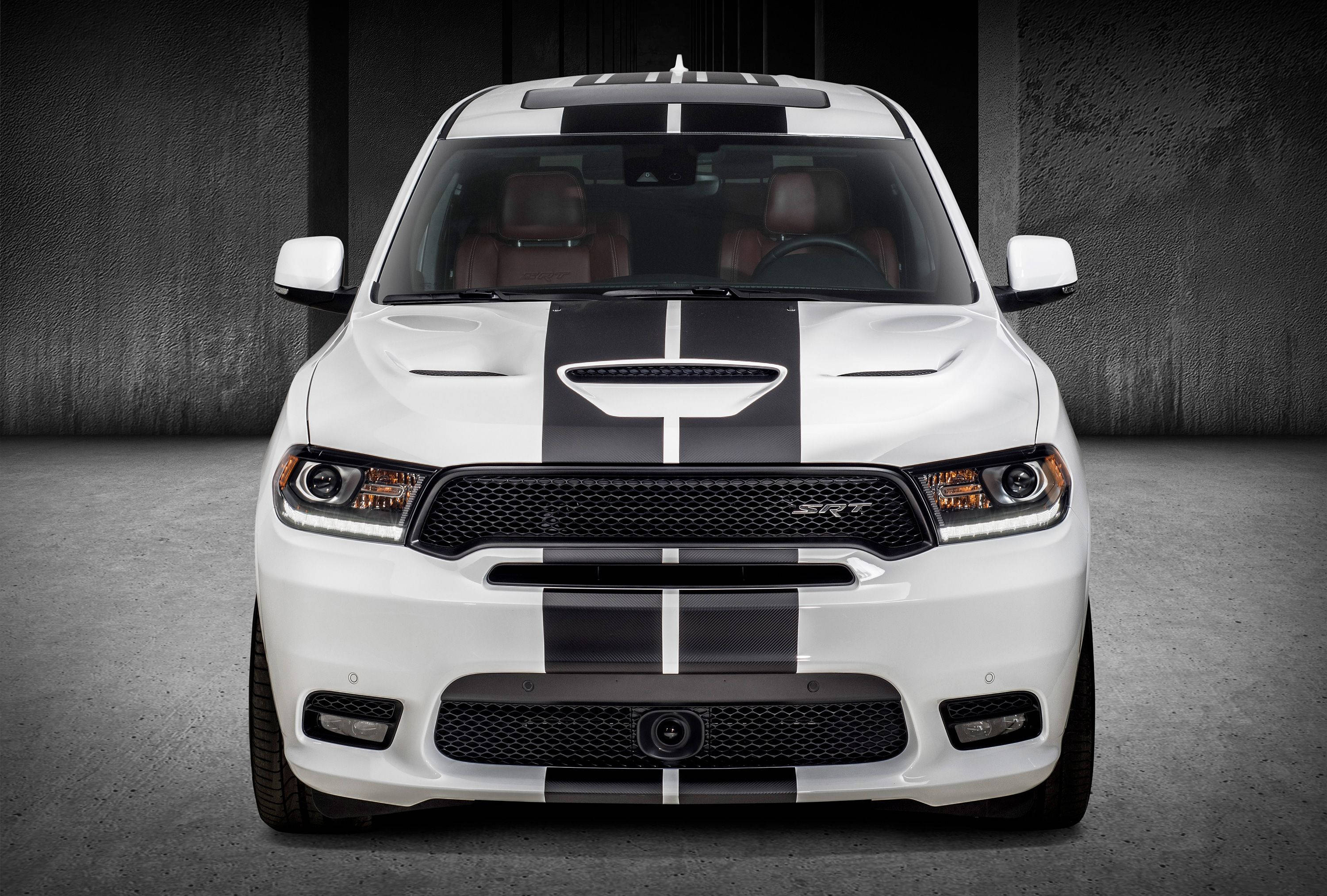 Mopar 桌布 壁紙 — 一輛白色 Dodge Ram SRT 帶有醒目黑色賽車條紋，停放在簡樸的混凝土車庫中，散發出原始力量和侵略性設計。