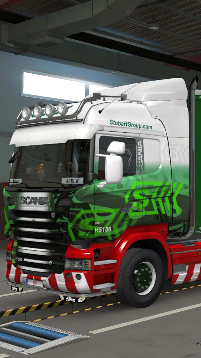 Simulation Games 桌布 壁紙 — 一輛白色、紅色和綠色的Scania卡車，帶有醒目的塗鴉風格圖案，停放在現代化車庫內，上方是明亮的螢光燈。