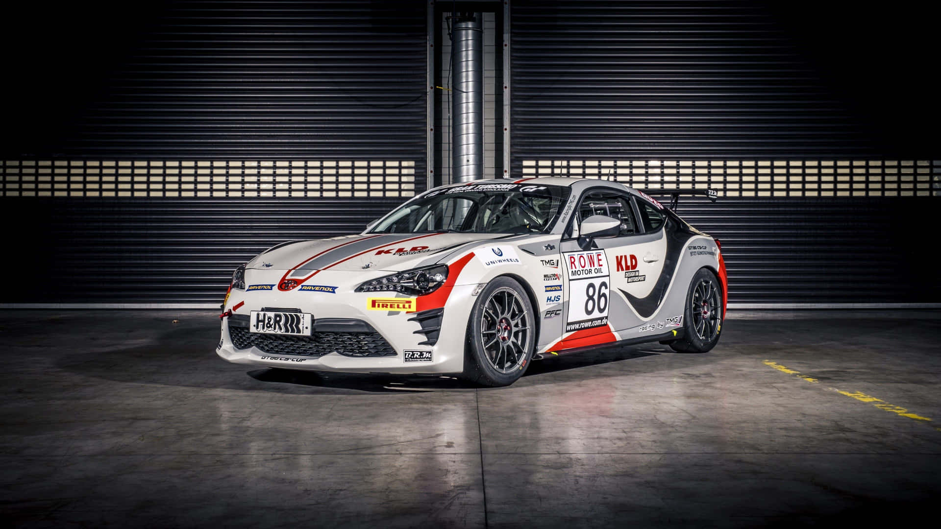 白色、紅色和黑色的86號賽車停放在一個黑暗的車庫中。 — Toyota Supra Mk4 壁紙