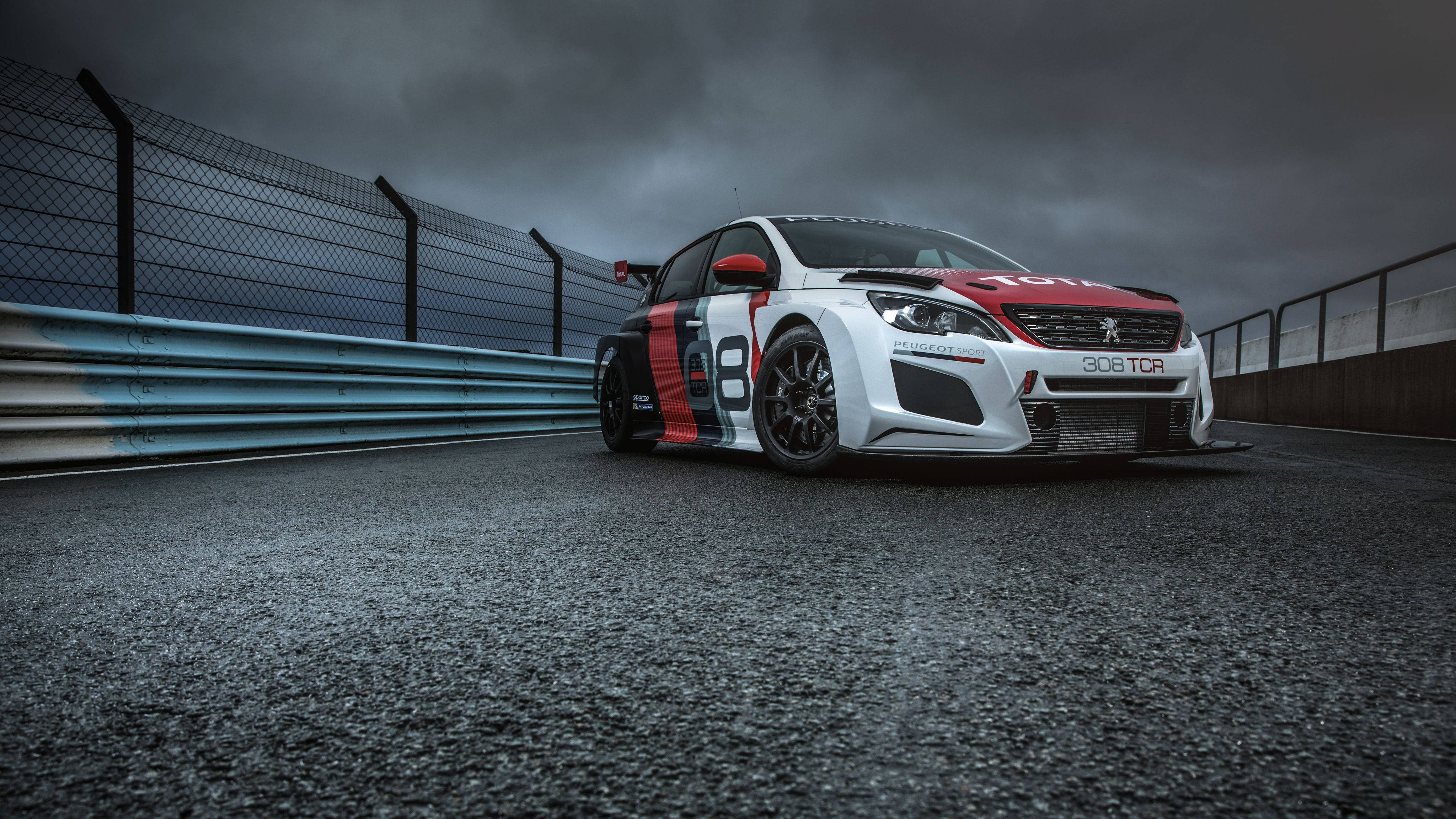 Peugeot 桌布 壁紙 — 一輛白色、紅色和黑色的標緻308 TCR賽車在暴風雨灰天下沿著濕滑的瀝青賽道飛馳。