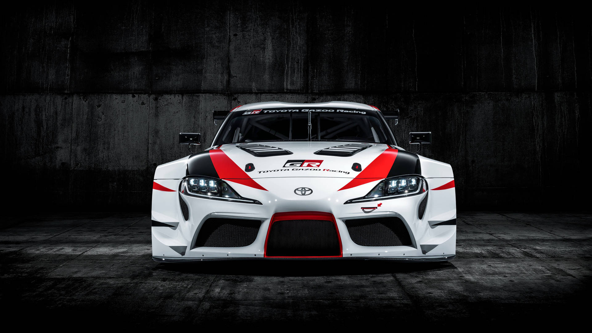 白色、紅色和黑色的豐田GR Supra賽車在昏暗的混凝土車庫中。 — Toyota Supra Mk4 壁紙