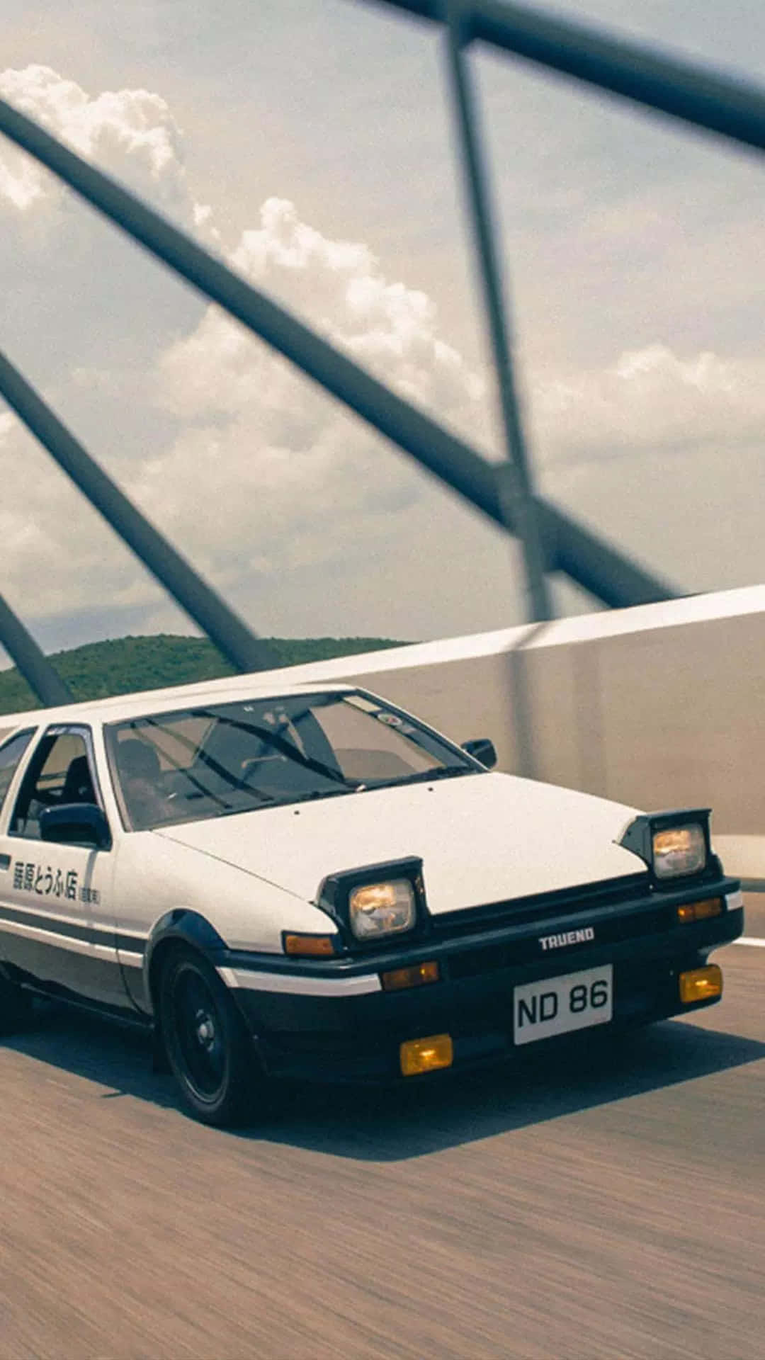 白色AE86跑車在橋上甩尾，天空多雲，有欄杆。 — Toyota Supra Mk4 壁紙