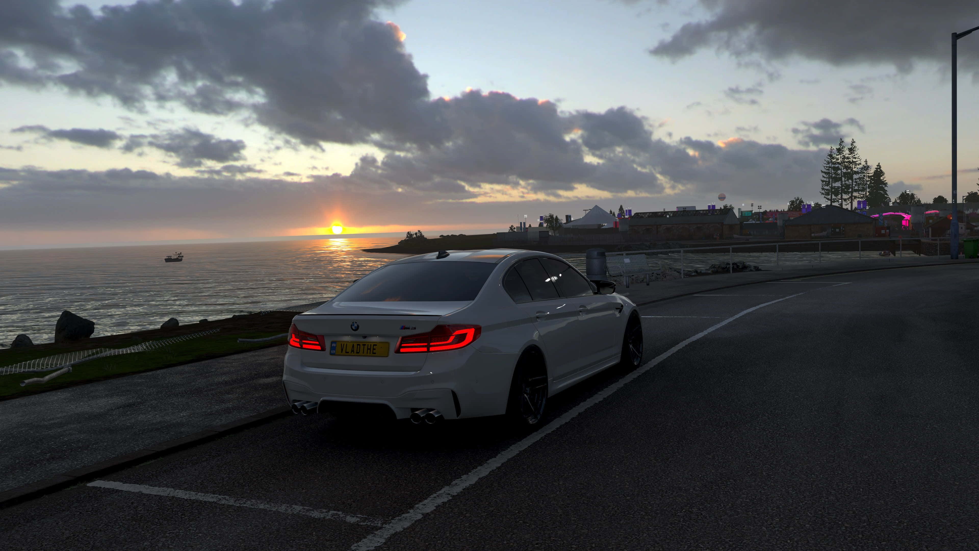電玩遊戲 桌布 壁紙 — 一輛白色BMW M5房車在日落時分沿海岸道路行駛，紅色尾燈閃爍，地平線上有船隻。
