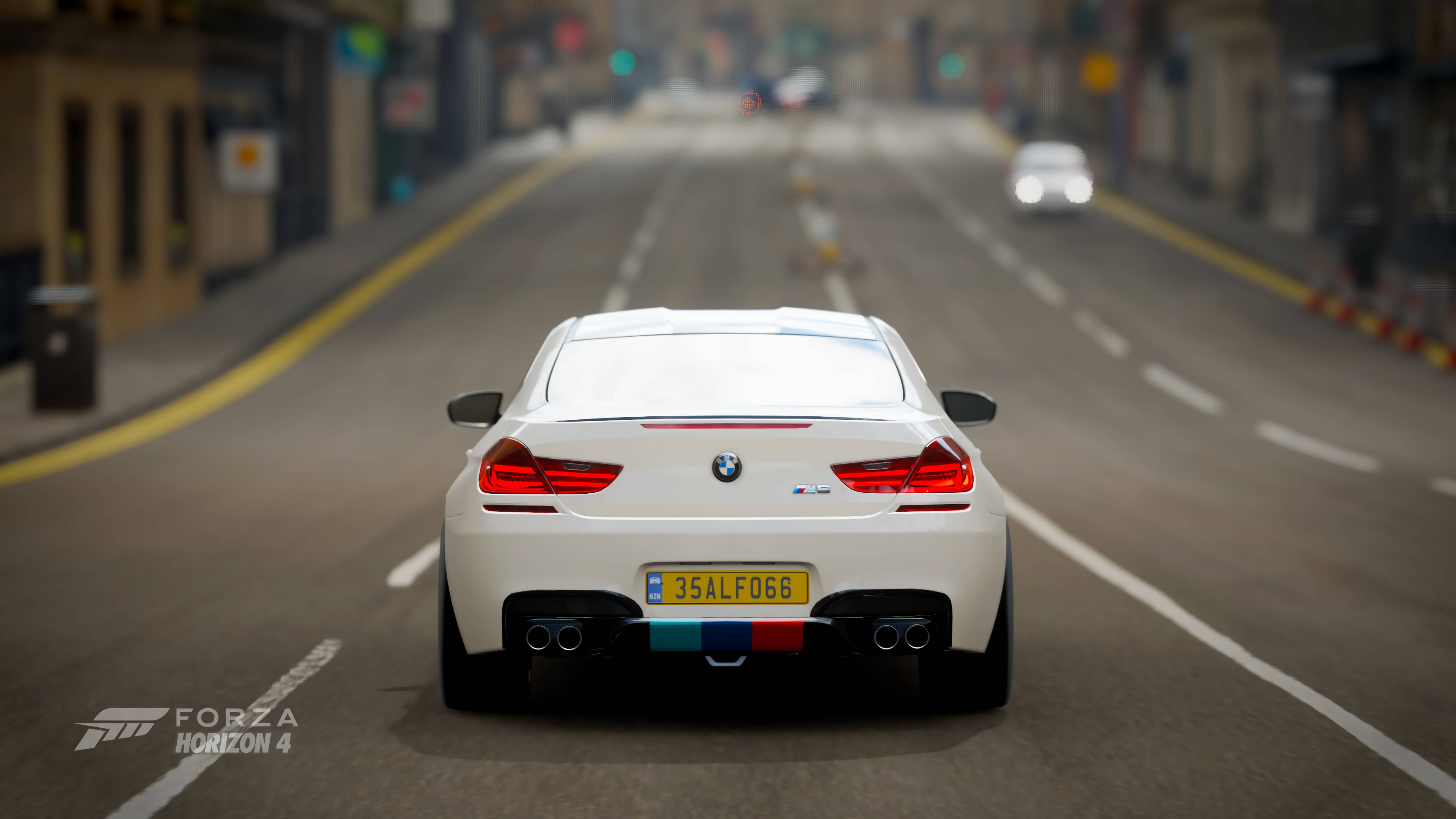 Horizon 桌布 壁紙 — 一輛白色BMW M6敞篷車在霧氣瀰漫的市區街道上行駛，背景是模糊的交通和商店櫥窗。
