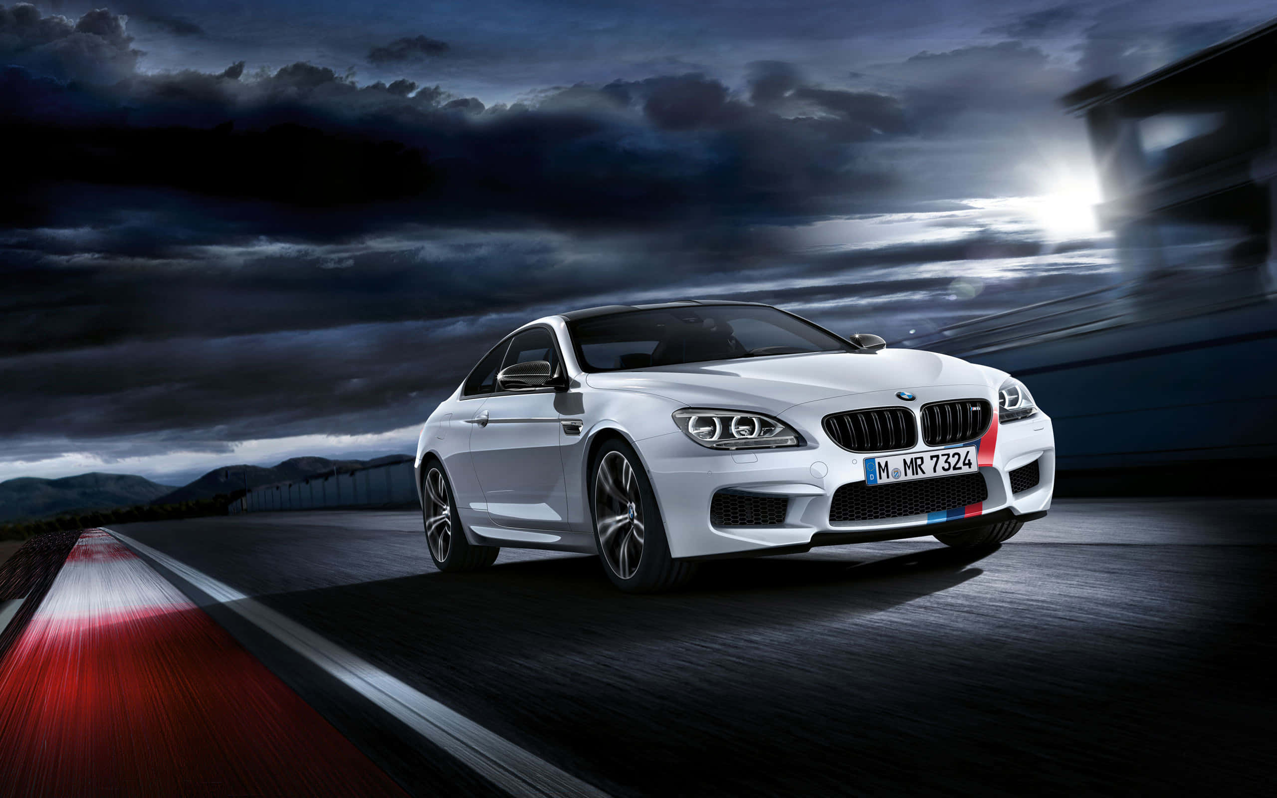 Bmw M6 桌布 壁紙 — 一輛白色BMW M6雙門跑車在暴風雨夜空的戲劇性雲層和模糊動態下，在濕滑道路上疾馳。