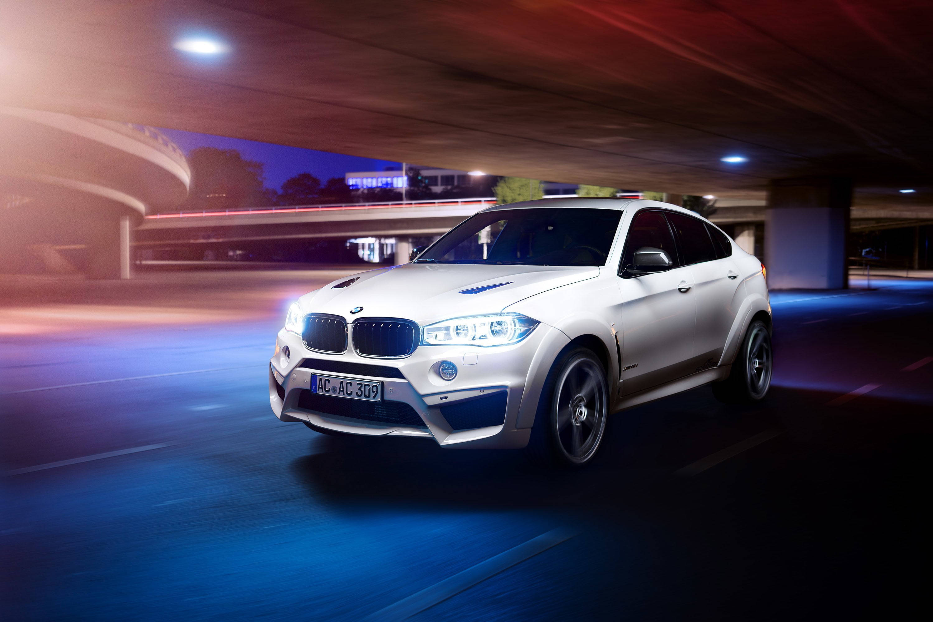 m 桌布 壁紙 — 一輛白色BMW X6 M在夜間於發光的城市高架橋下疾馳，帶有藍色和紅色光的動態模糊條紋。