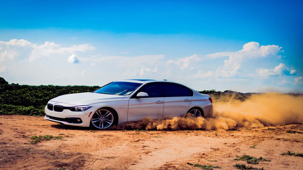 720p Bmw 桌布 壁紙 — 一輛白色BMW轎車在晴朗藍天白雲下，於乾燥泥地上高速行駛，揚起塵土。