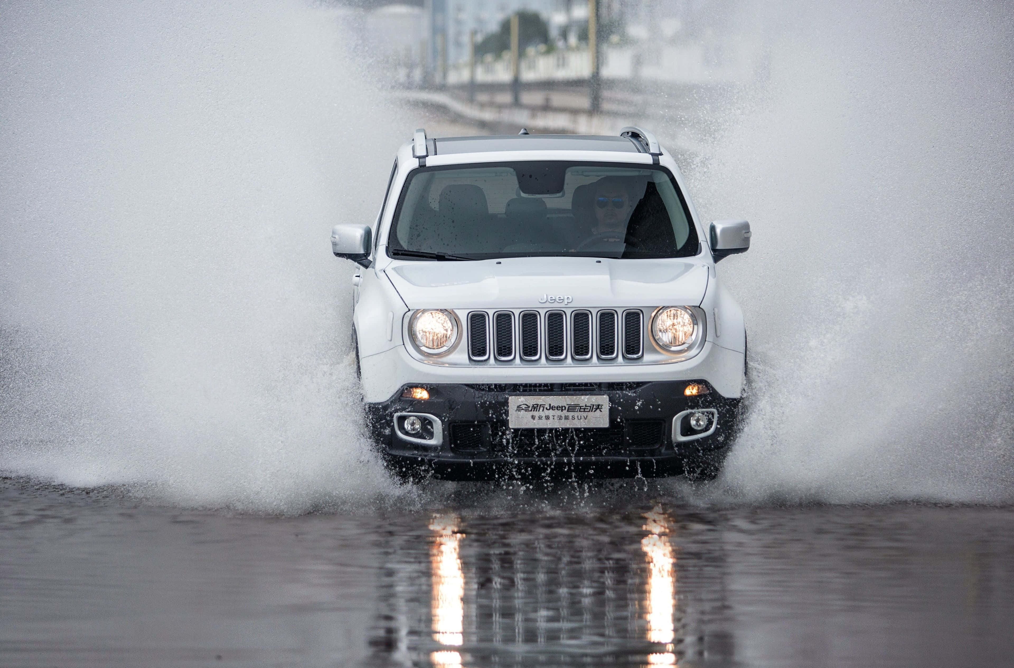 Jeep Renegade 桌布 壁紙 — 一輛白色Jeep Renegade開著頭燈，戲劇性地駛過深水，濺起大量水花。