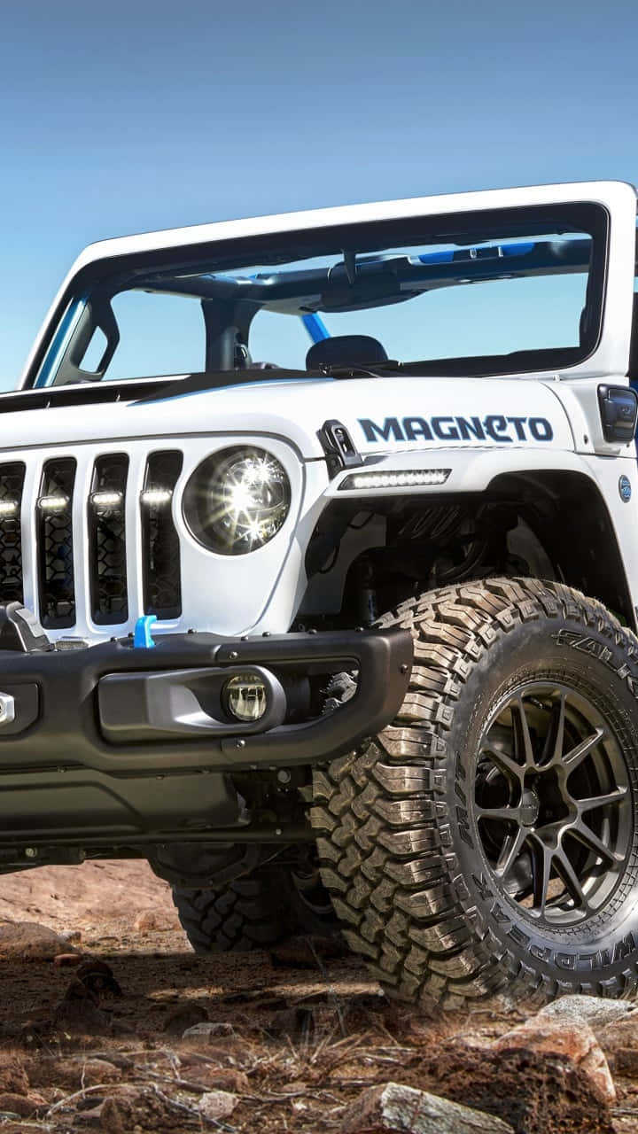 吉普 桌布 壁紙 — 一輛白色Jeep Wrangler Magneto配備堅固輪胎，在晴朗藍天下屹立於岩石地形上。
