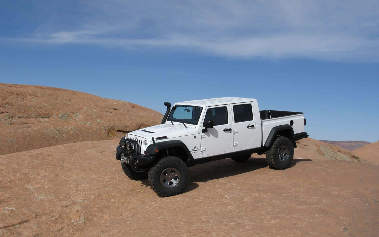 Jeep Gladiator 桌布 壁紙 — 一輛白色Jeep Wrangler pickup truck停放在陽光普照的紅岩沙漠山脊上，背景是清澈的藍天。
