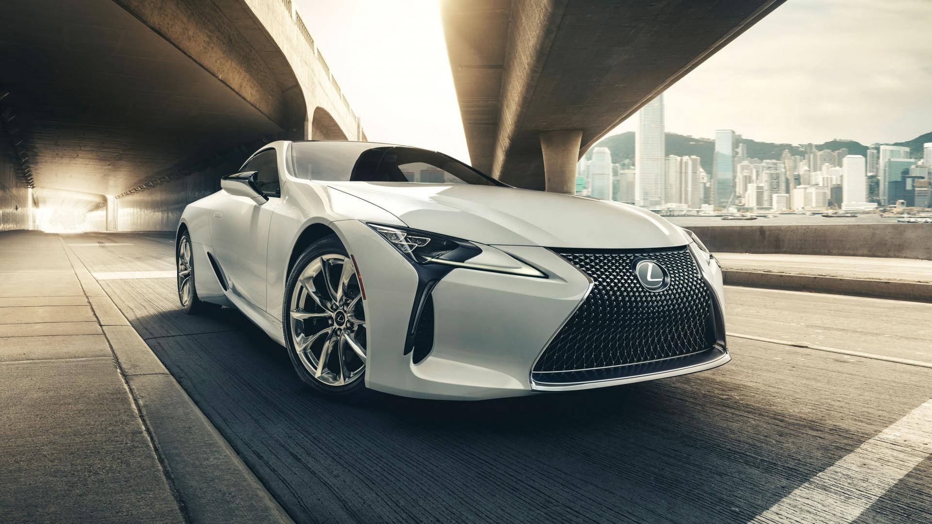 凌志 桌布 壁紙 — 一輛白色Lexus跑車在混凝土高架橋下滑行，背景是閃爍的城市天際線。