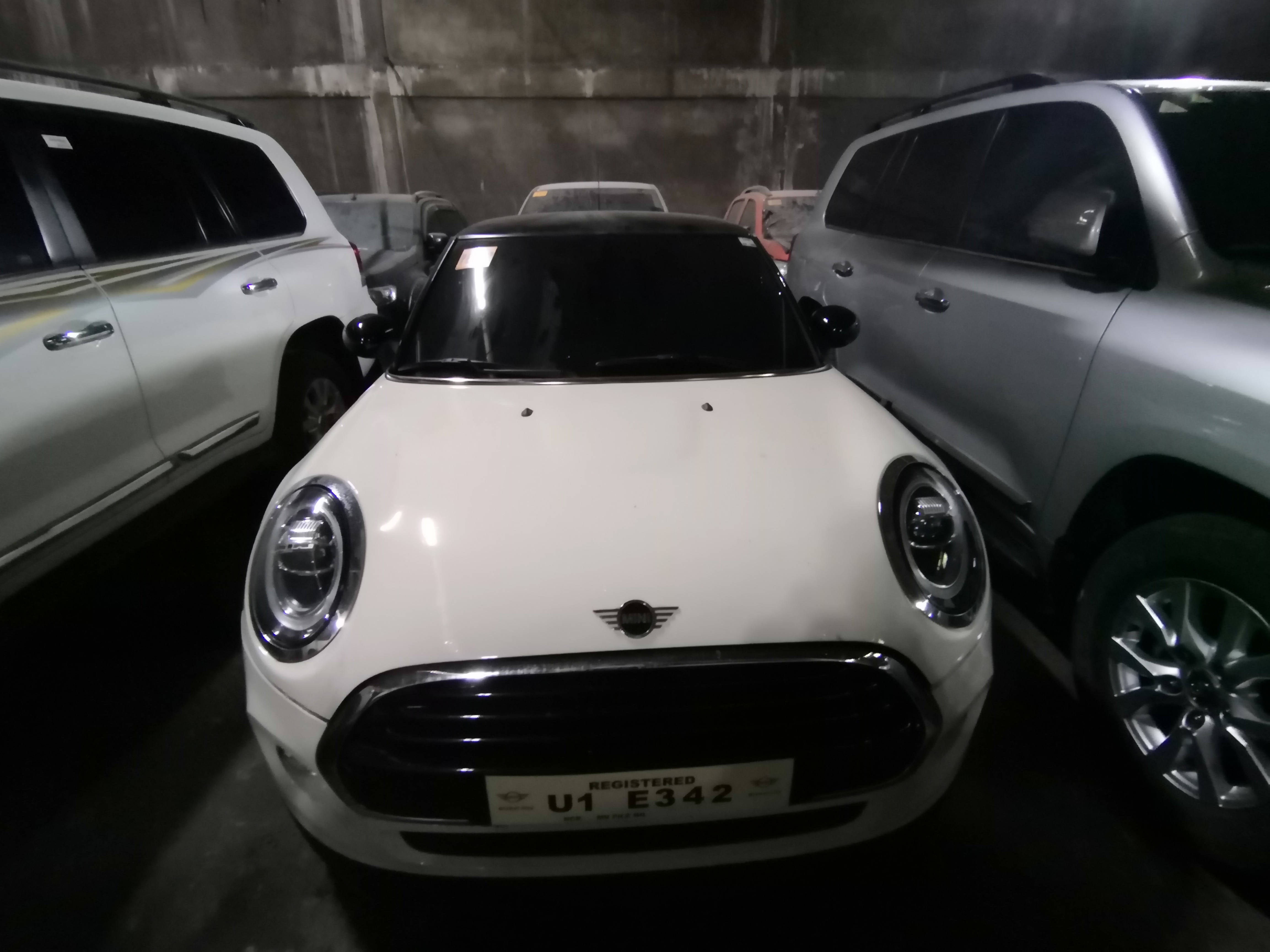 Mini 桌布 壁紙 — 一輛白色Mini Cooper停放在燈光昏暗的地下停車場，周圍有其他車輛。