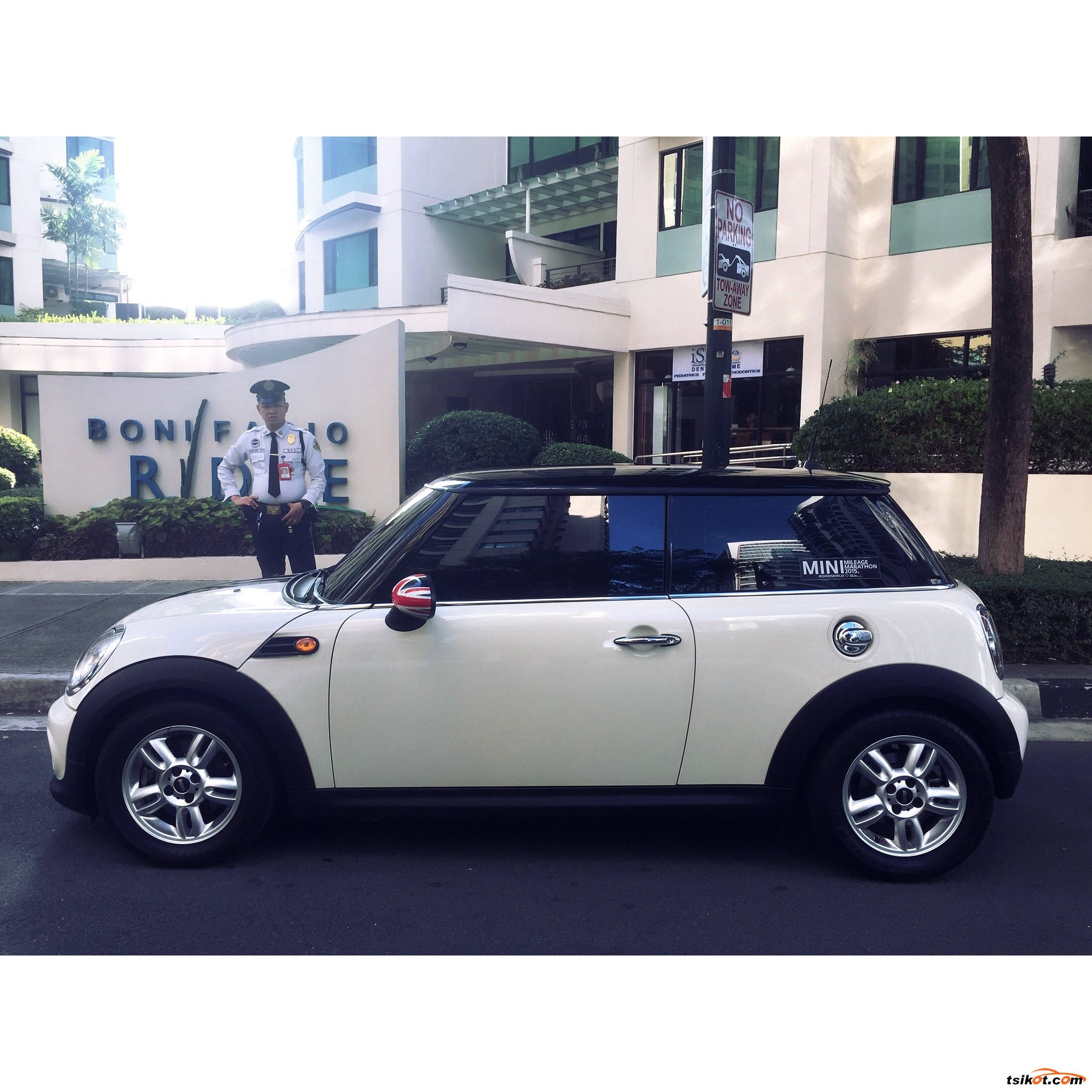黑白 桌布 壁紙 — 一輛白色MINI Cooper停泊在Bonifacio Global City外面，附近有一名保安人員在明亮的日光下站立。