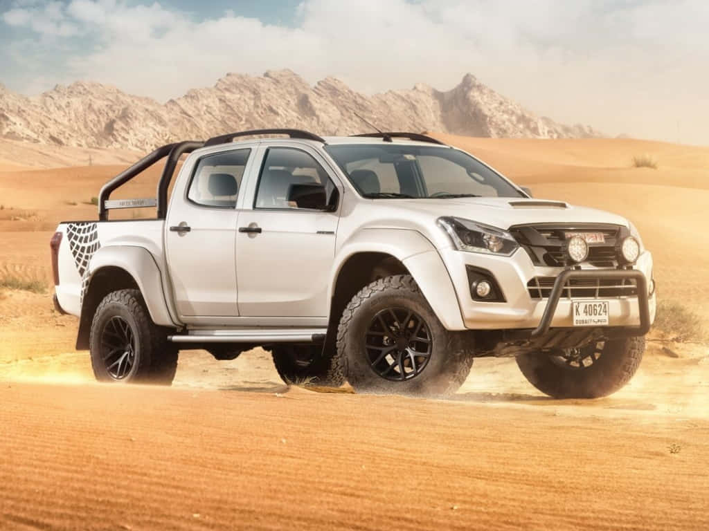 Isuzu 桌布 壁紙 — 一輛白色五十鈴皮卡車，配備黑色輪圈和越野裝備，在岩石山脈背景下的沙漠中行駛，揚起沙塵。