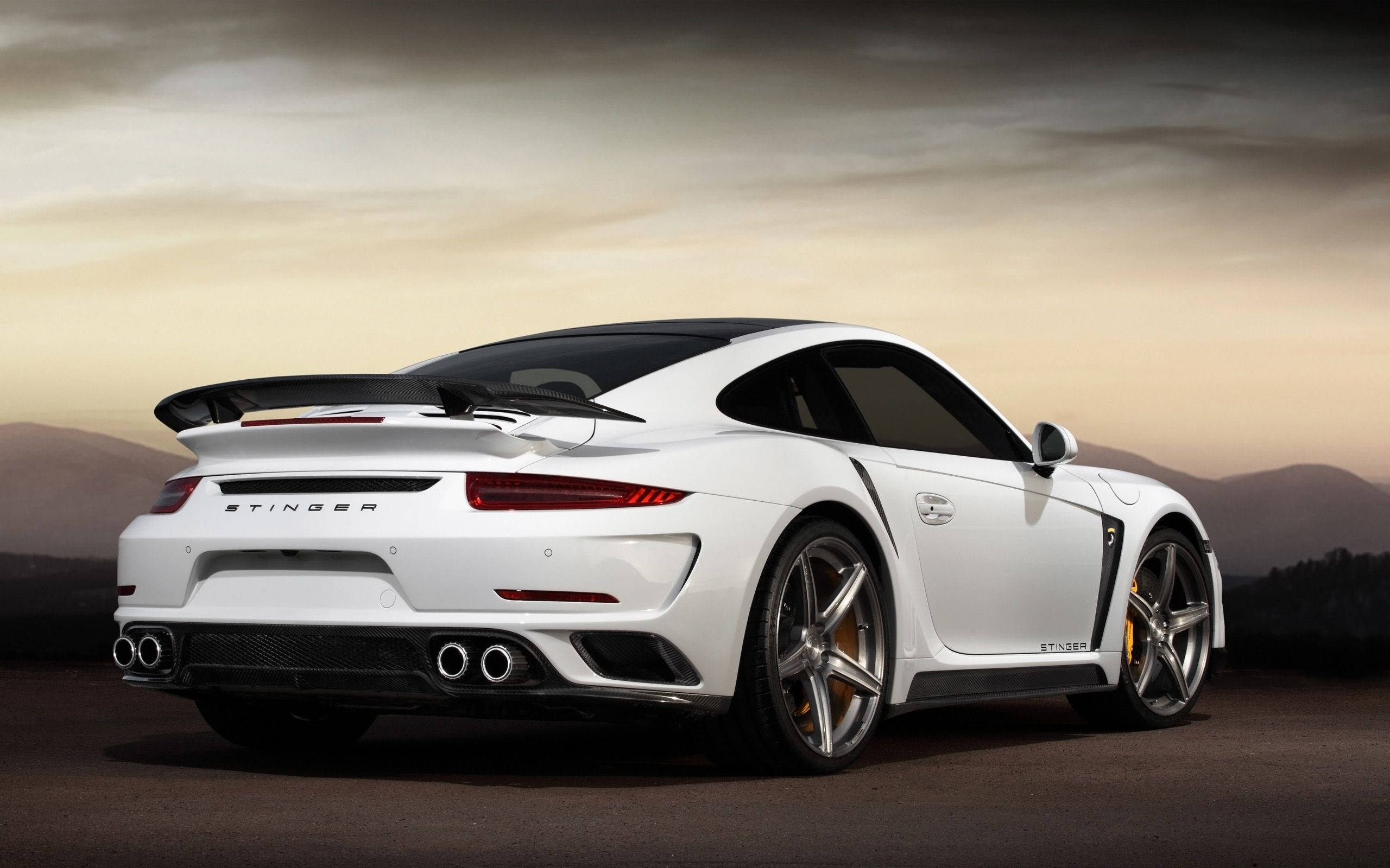 保時捷 桌布 壁紙 — 一輛白色保時捷911 Turbo S Stinger在日落時分停在沙漠公路上，背景是山脈。