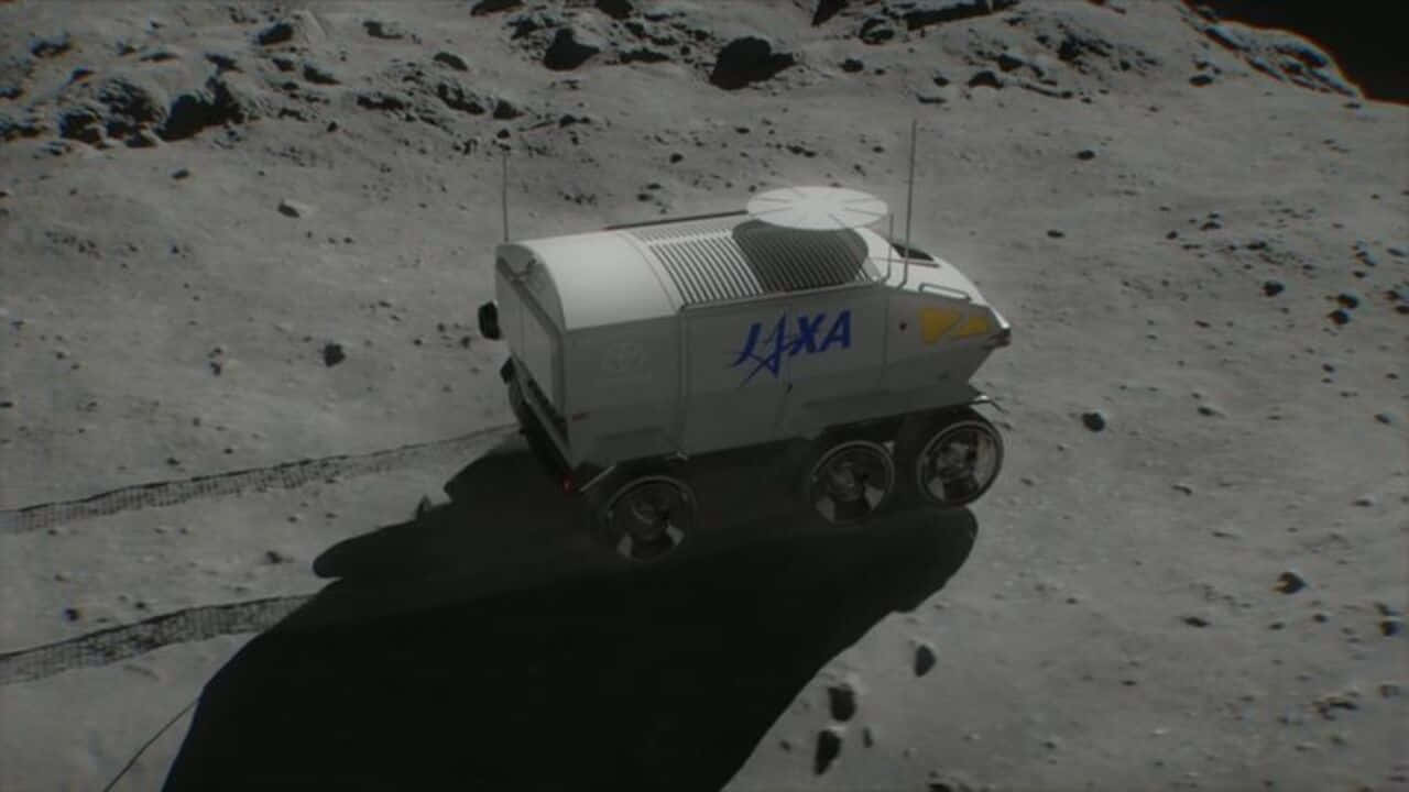 Lunar Rover 桌布 壁紙 — 一輛白色六輪JAXA月球車在佈滿岩石的灰色月球表面行駛，在明亮的陽光下投下長長的影子。