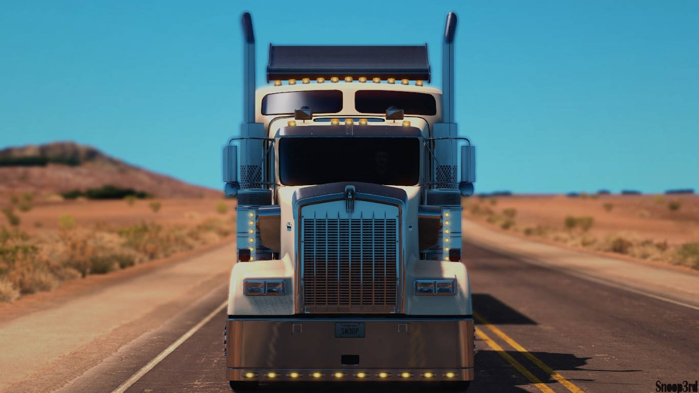 American Truck Simulator 桌布 壁紙 — 一輛白色半掛卡車在晴朗藍天和遠山下的沙漠高速公路上向前行駛。