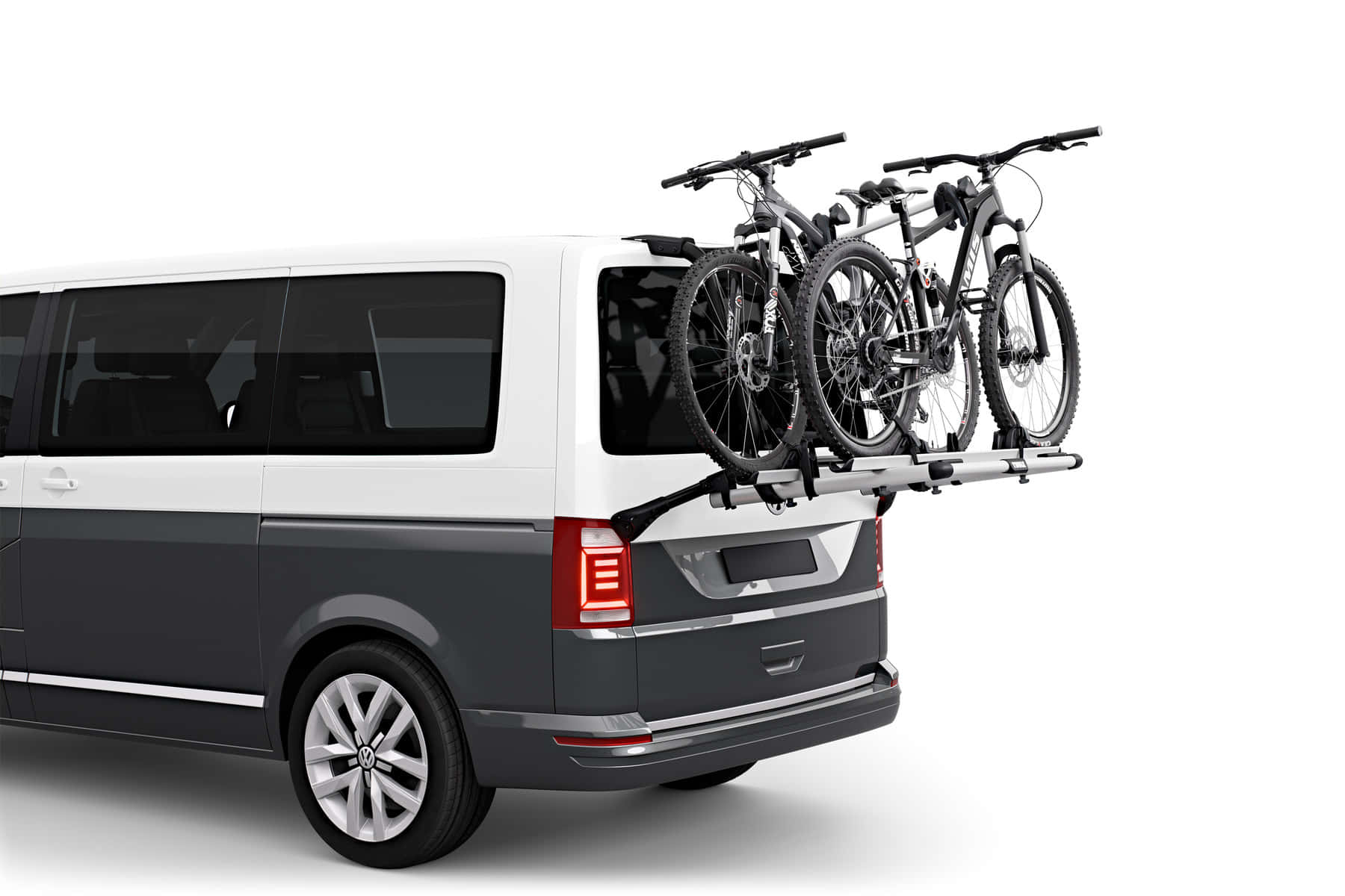 Best Bikes 桌布 壁紙 — 一輛白色和灰色的廂型車，後車頂架上安全地安裝了兩輛登山自行車，背景為純白色。