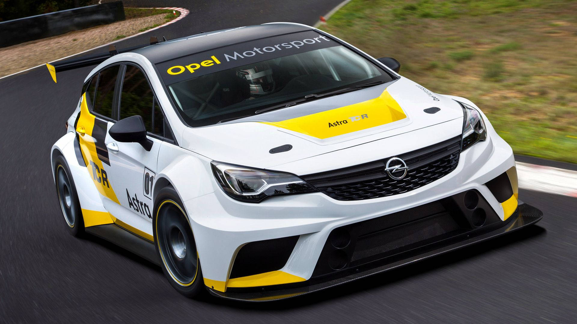 Opel 桌布 壁紙 — 一輛白色和黃色的歐寶雅特賽車在潮濕的賽道上飛馳，背景有模糊的動感和綠草。