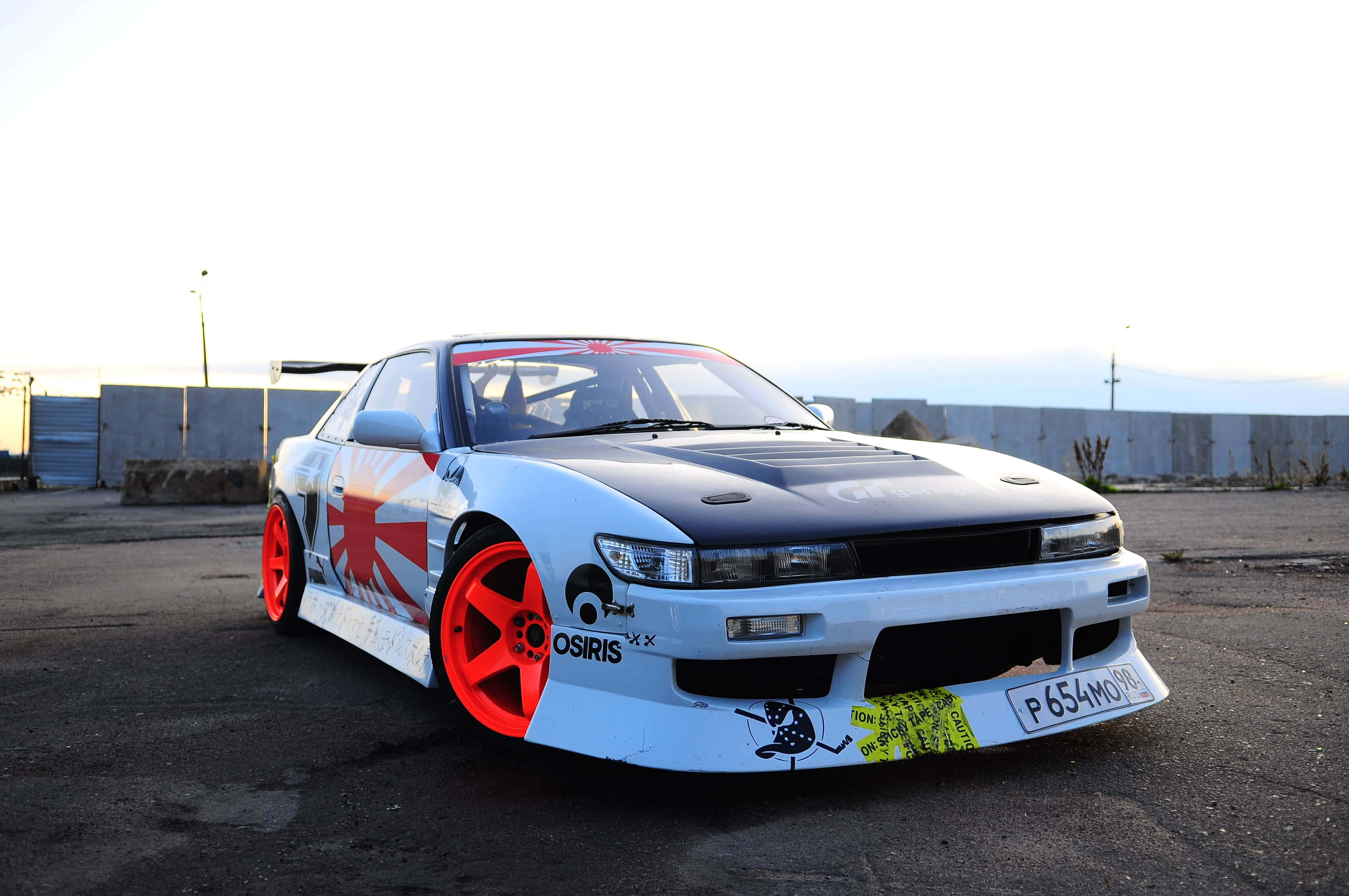 JDM 桌布 壁紙 — 一輛白色和黑色的甩尾車，帶有紅色輪圈和日本國旗塗裝，在黃昏時停在柏油路上。