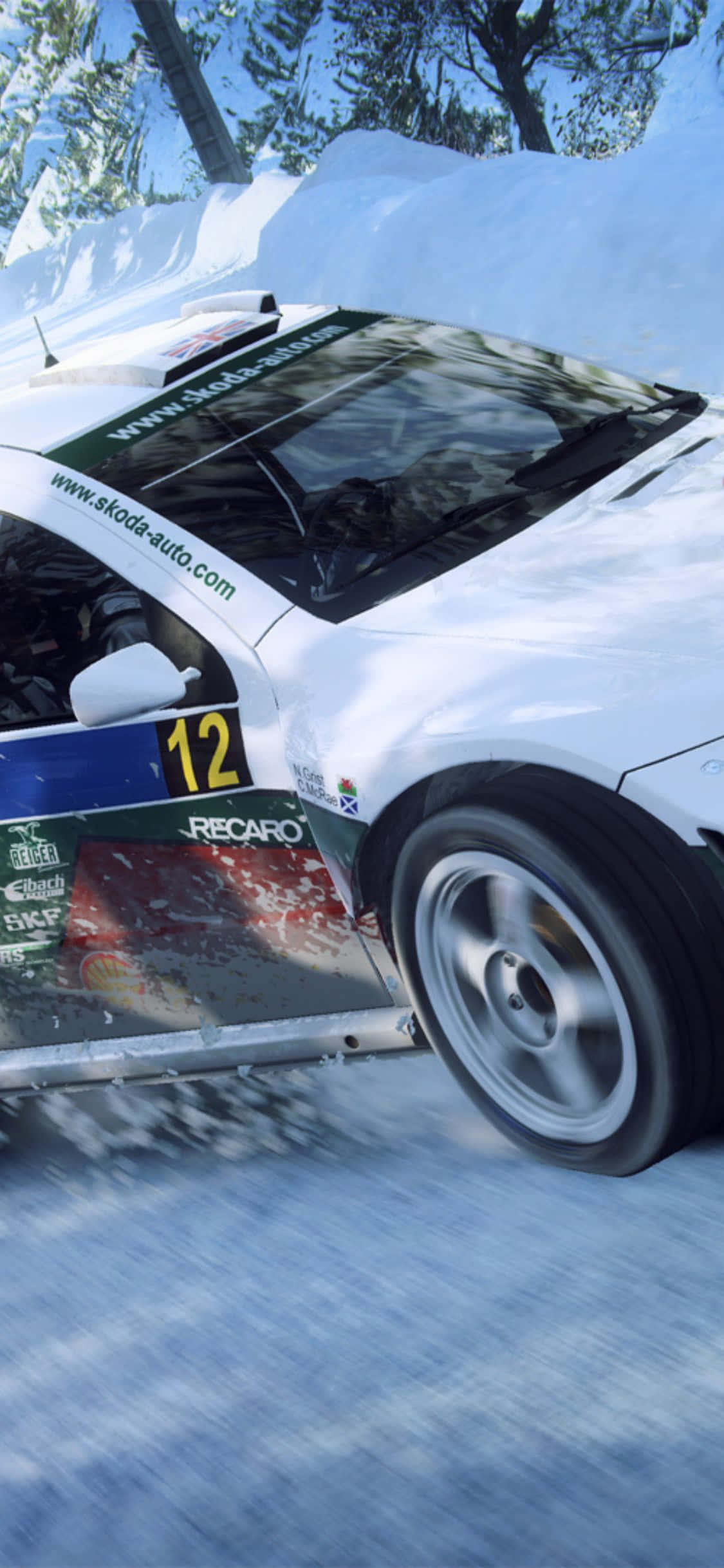 iPhone X Dirt Rally 桌布 壁紙 — 一輛白色拉力賽車，編號12，在雪地森林賽道上飛馳，揚起雪霧。