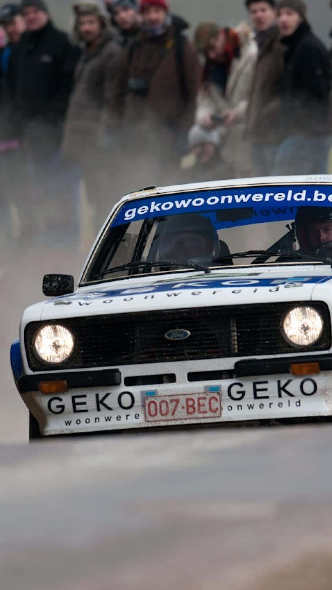 Ford Escort 桌布 壁紙 — 一輛白色拉力賽車在冬季比賽中高速駛過觀眾，激起霧氣。