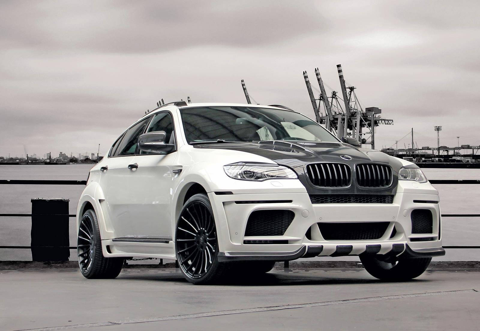 m 桌布 壁紙 — 一輛白色改裝BMW X6運動型多功能車，帶有黑色飾邊，停泊在工業起重機附近的碼頭，天空多雲。